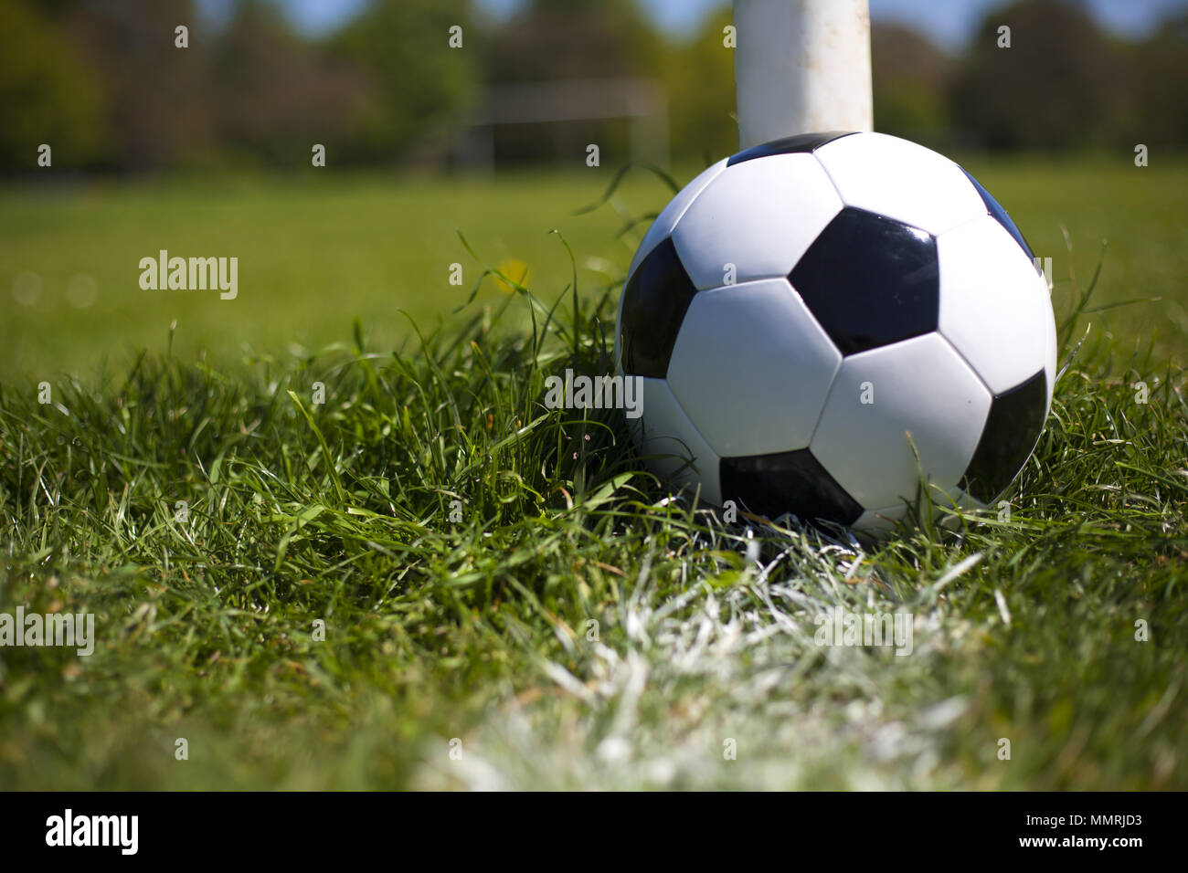 A black and white leather football near the post and white line Stock Photo