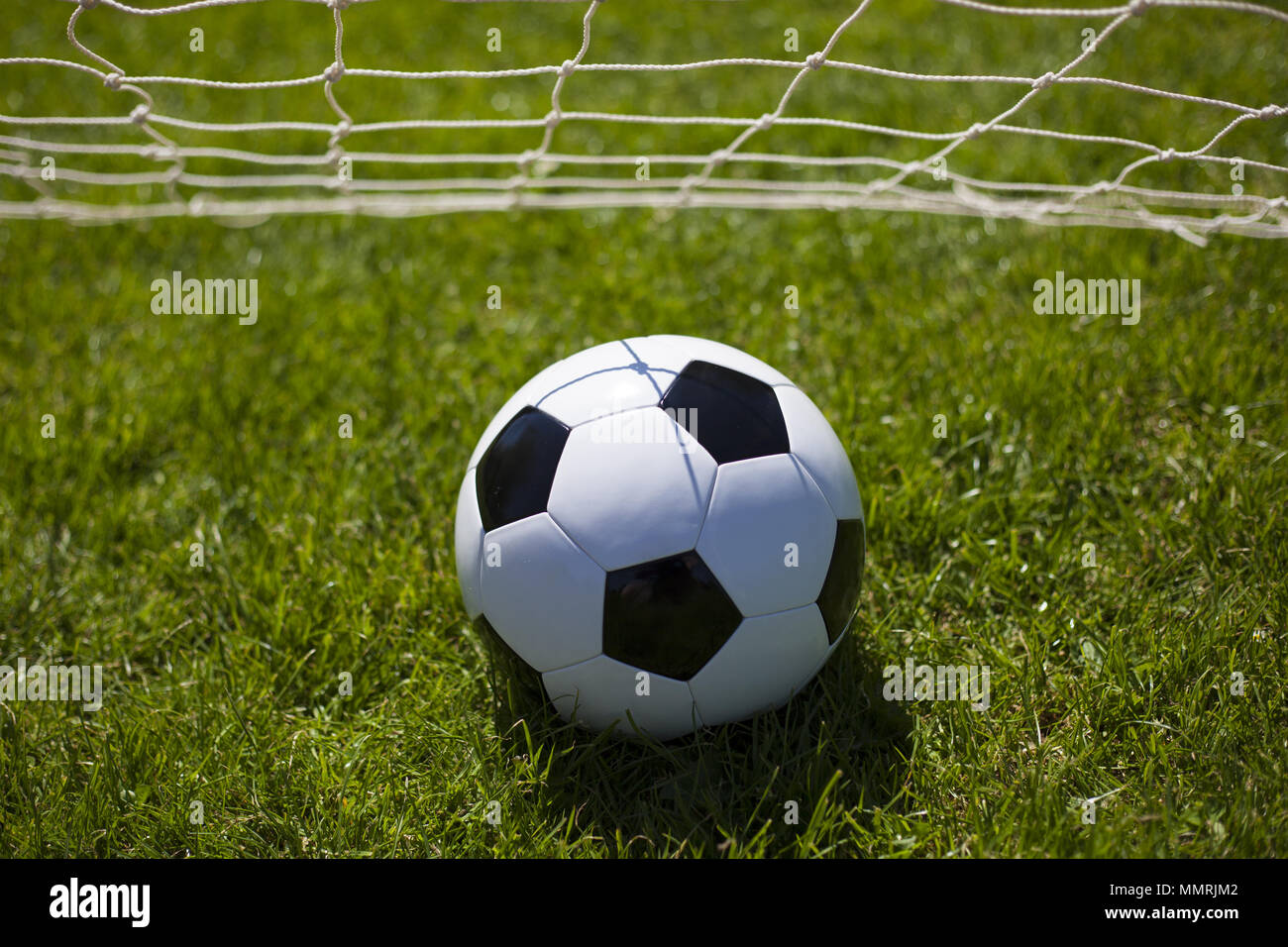 A black and white football in the middle of the net Stock Photo