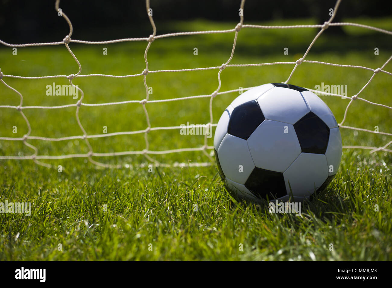 A black and white football in the net Stock Photo