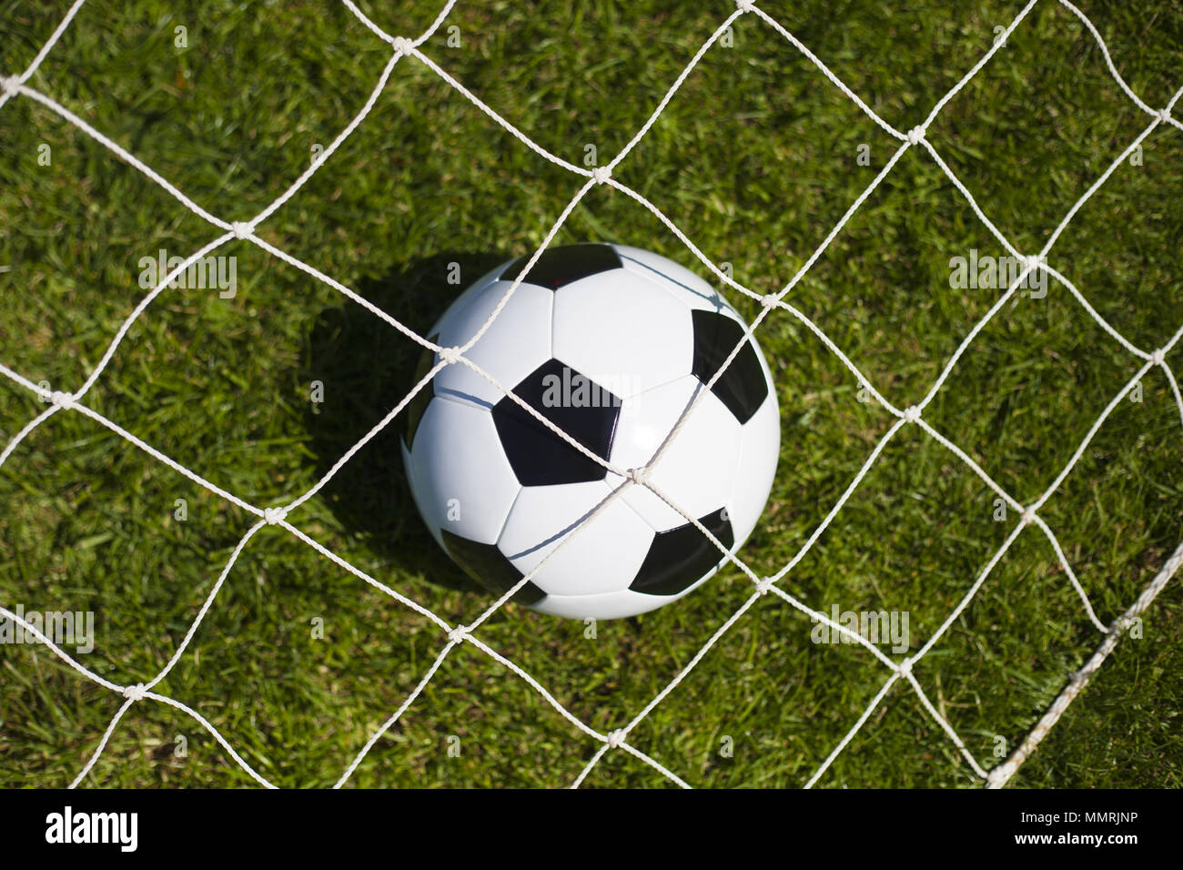 A black and white football in the middle of the net Stock Photo