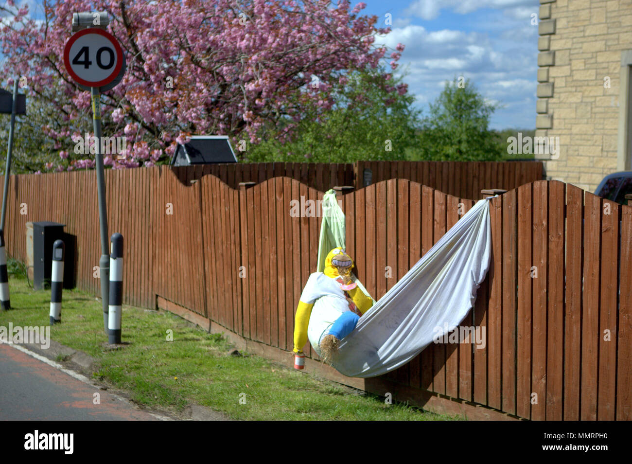 Glasgow, Scotland, UK 12th May.UK Weather:Carmunnock Gala Day  was highlighted by its topical scarecrow competition as sunshine made the day a hot one, The ubiquitous Homer Simpson in a hammock in the entrance road to the village centre.  Gerard Ferry/Alamy news Credit: gerard ferry/Alamy Live News Stock Photo