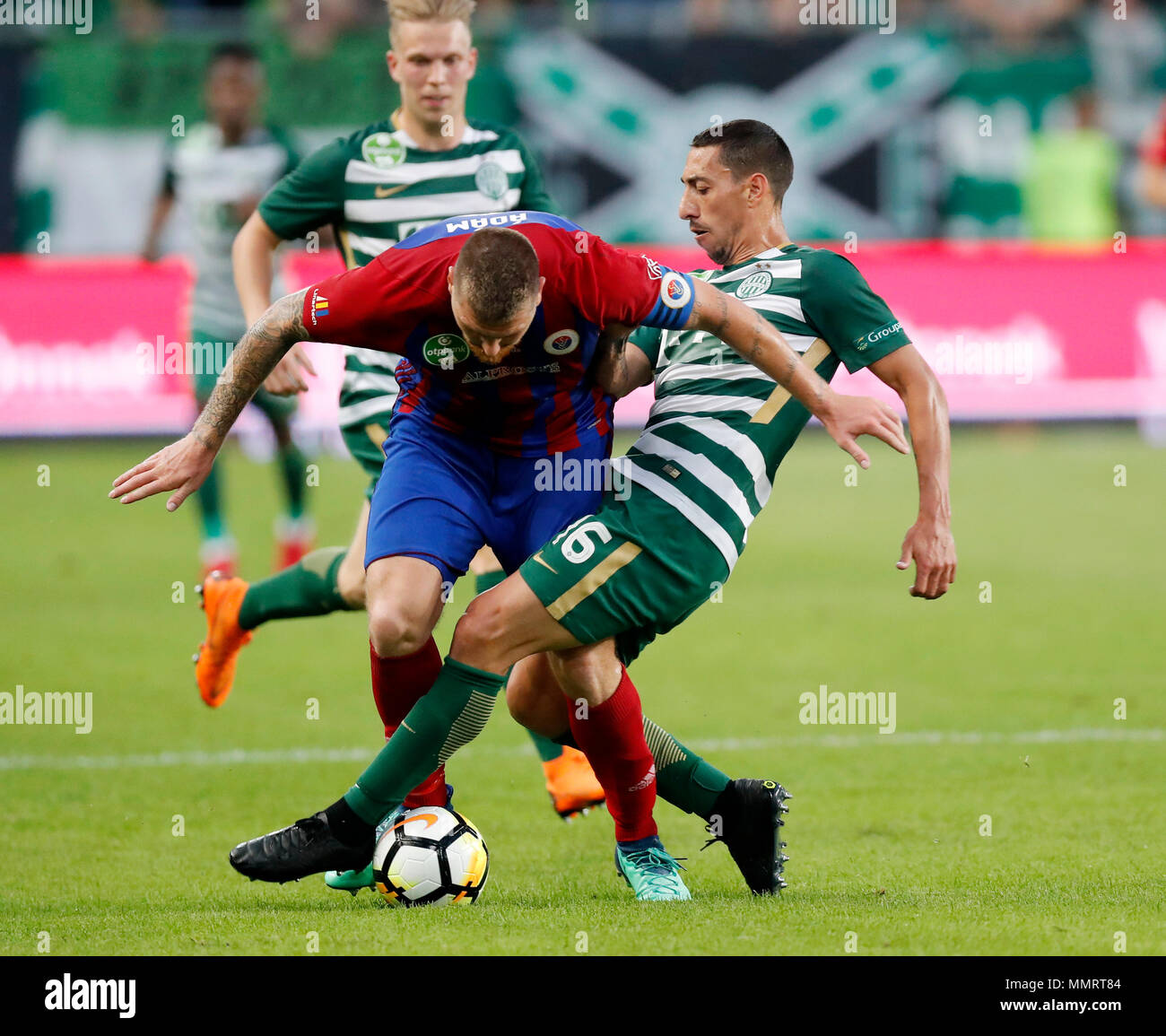 BUDAPEST, HUNGARY - MAY 12: (r-l) Leandro De Almeida 'Leo' of Ferencvarosi TC tackles Martin Adam of Vasas FC in front of Janek Sternberg of Ferencvarosi TC during the Hungarian OTP Bank Liga match between Ferencvarosi TC and Vasas FC at Groupama Arena on May 12, 2018 in Budapest, Hungary. Stock Photo
