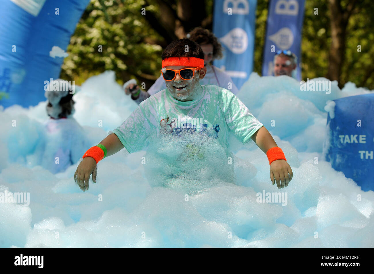 Bubble Run, Runners enjoy the bubbles whilst raising money for charity. Credit: Finnbarr Webster/Alamy Live News Stock Photo