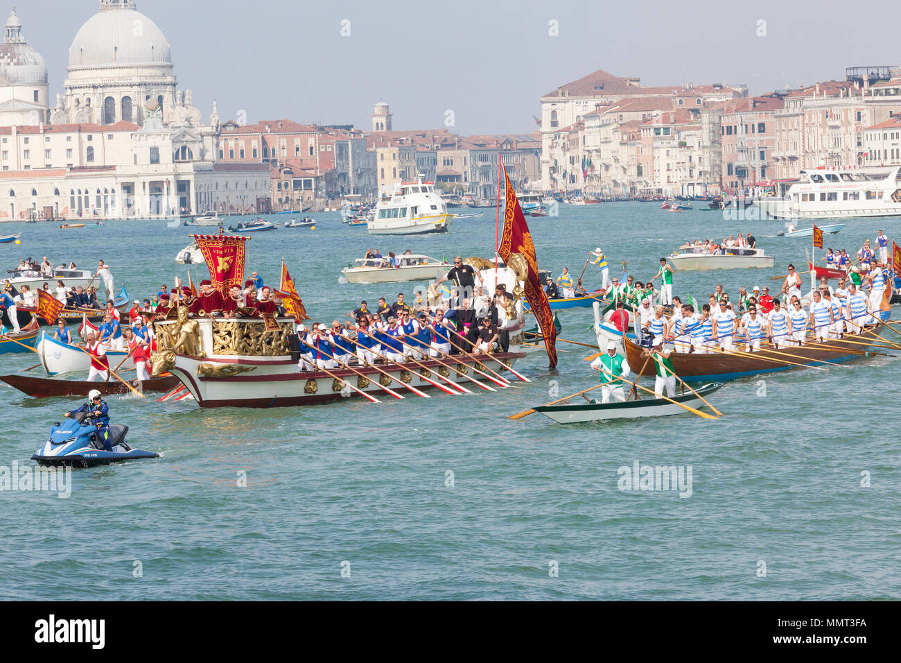 Venice, Veneto, Italy.  13th May 2018. View of St Marks Basin with the cortege of rowers in the boats accompanying the Serenissama ceremonial boat with the dignitaries to Lido during Festa de la Sensa for the blessing of the gold ring which is then tossed into the lagoon marrying Venice to the sea. Credit Mary Clarke/Alamy Live News Stock Photo