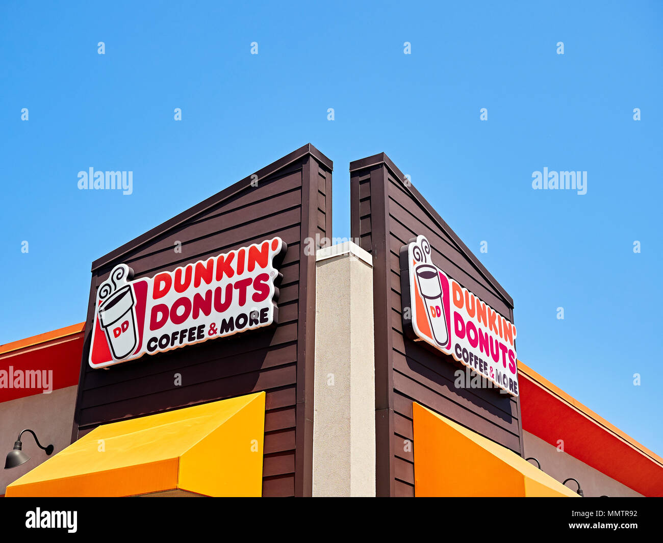 Dunkin Donuts fast food restaurant exterior sign with corporate logo. Stock Photo