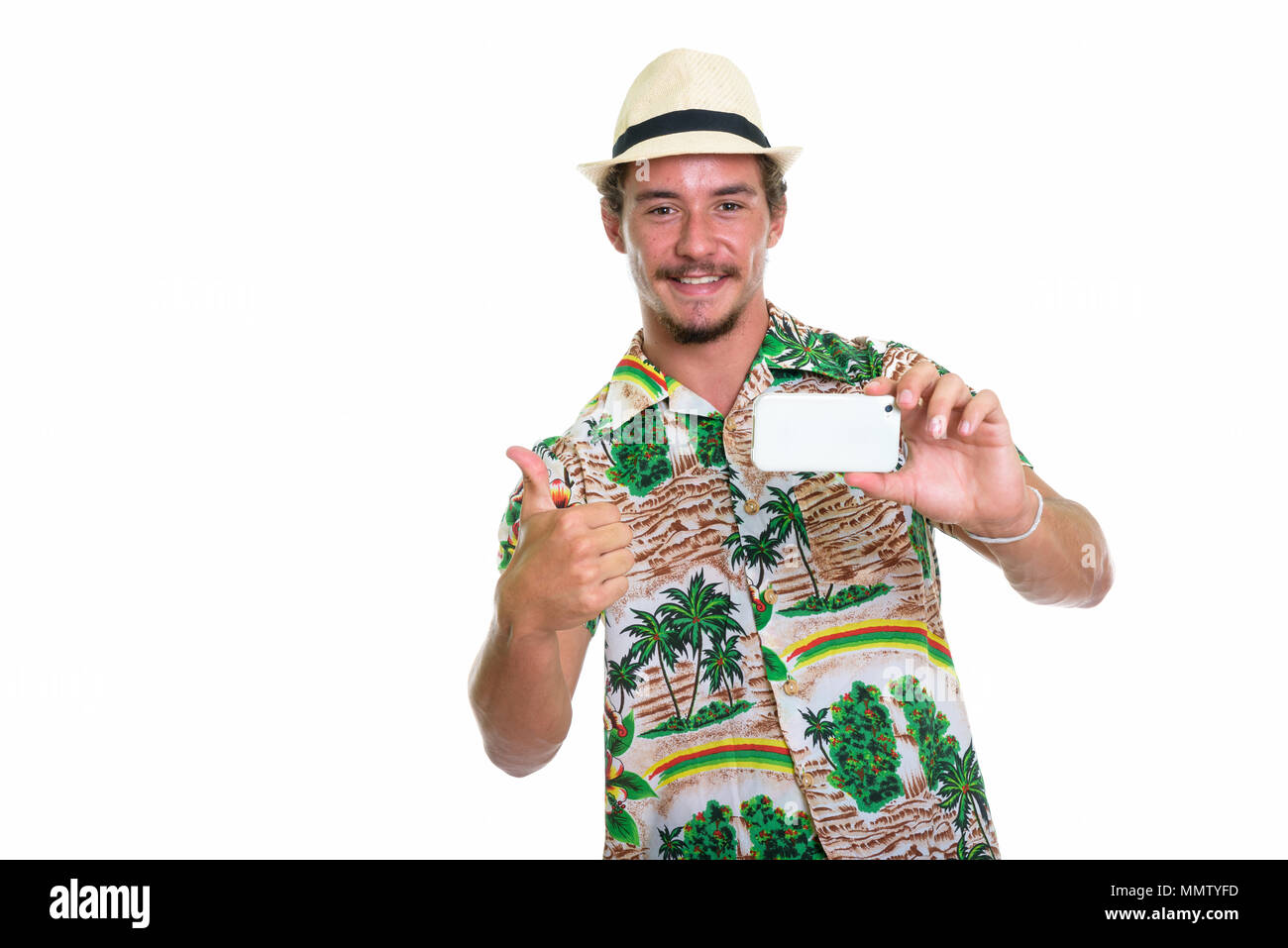Studio shot of young happy tourist man smiling while taking pict Stock Photo