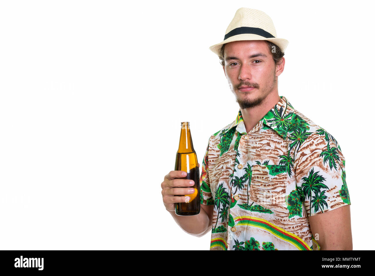 Studio shot of young handsome tourist man holding bottle of beer Stock Photo