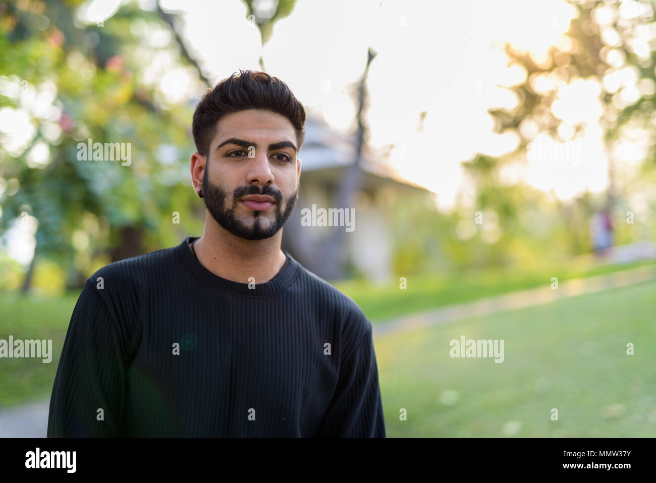 Young handsome Indian man at park Stock Photo