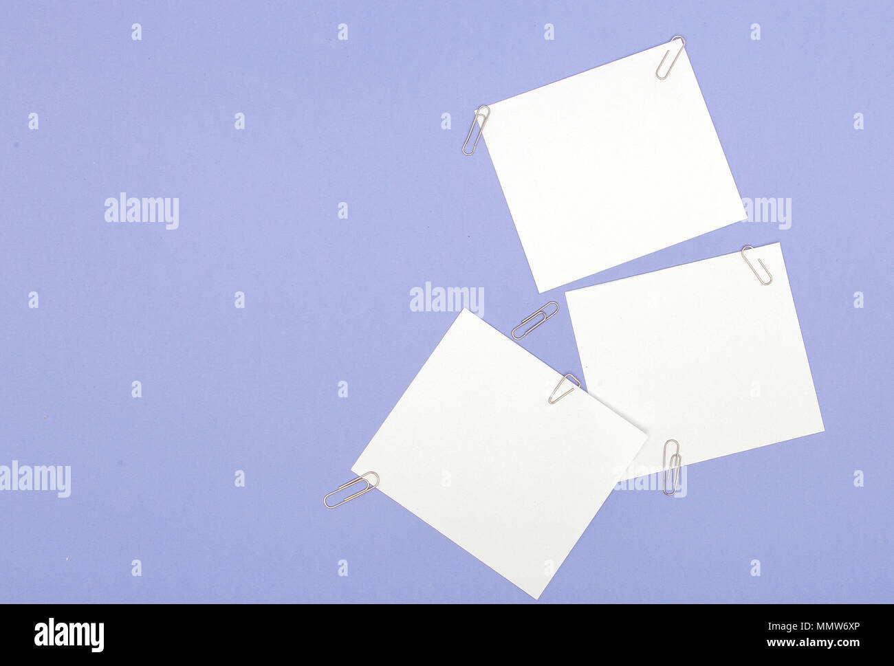 Blank note papers label with clip on purple background. Stock Photo