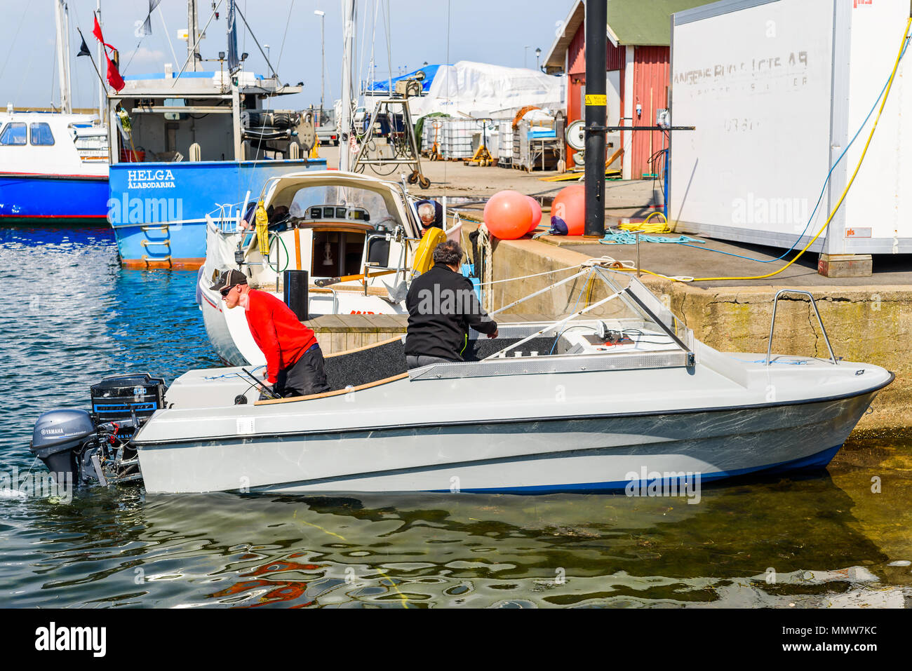 Alabodarna, Sweden - April 29, 2018: Documentary of everyday life and place. Two persons in a gray motorboat, leaving for a trip at sea. Stock Photo