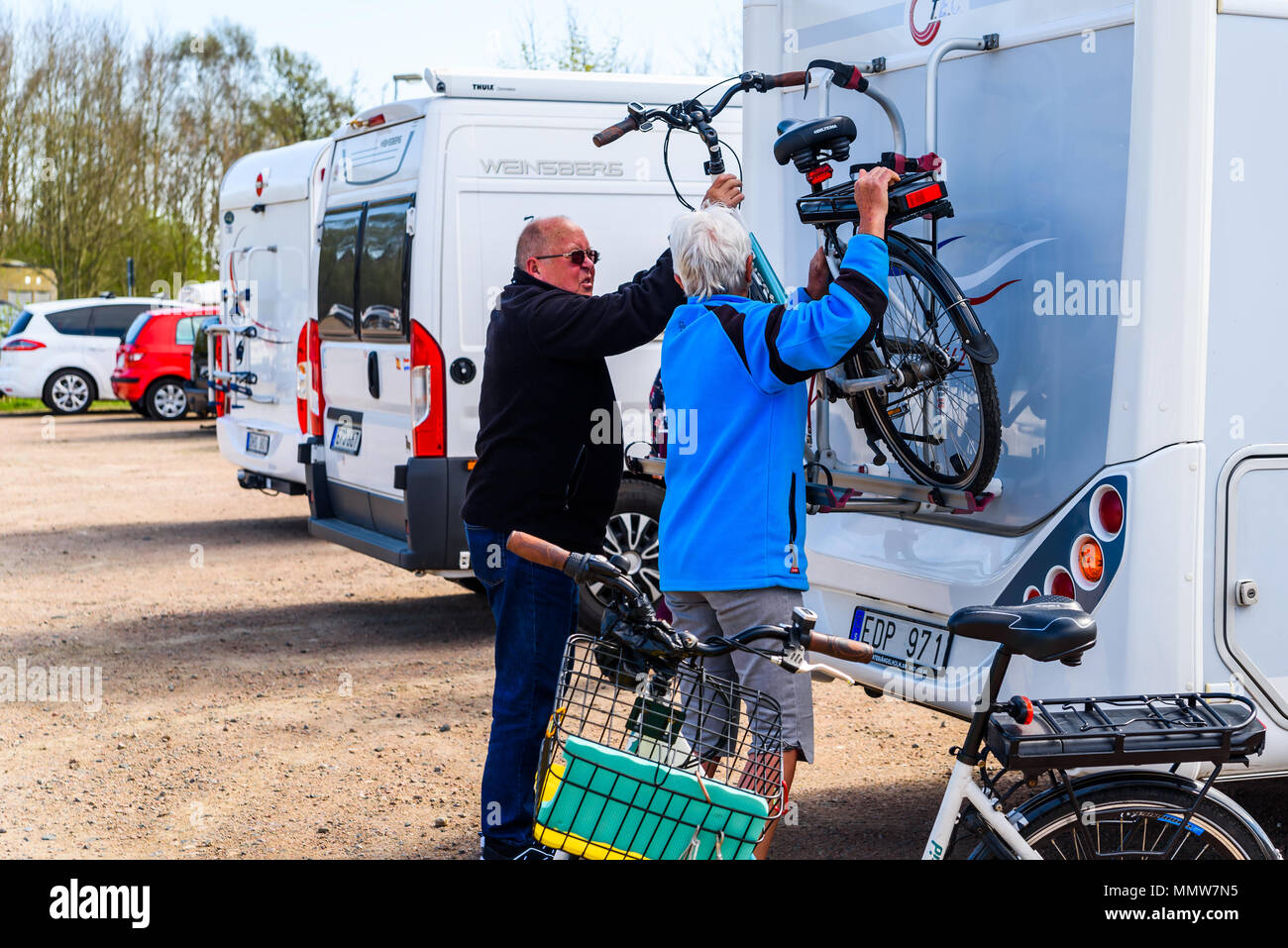 Raa harbor, Helsingborg, Sweden - April 29, 2018: Documentary of everyday life and place. Senior couple loading a bicycle onto the end of a camper whi Stock Photo