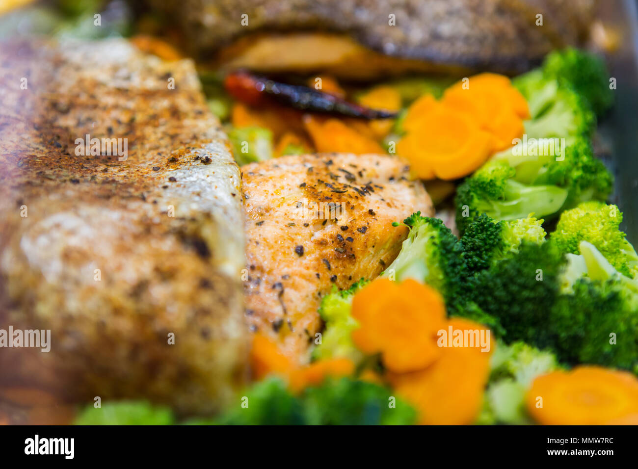 Close up of a delicious plate of meal consists of broccoli, carrots and salmon fish. Stock Photo