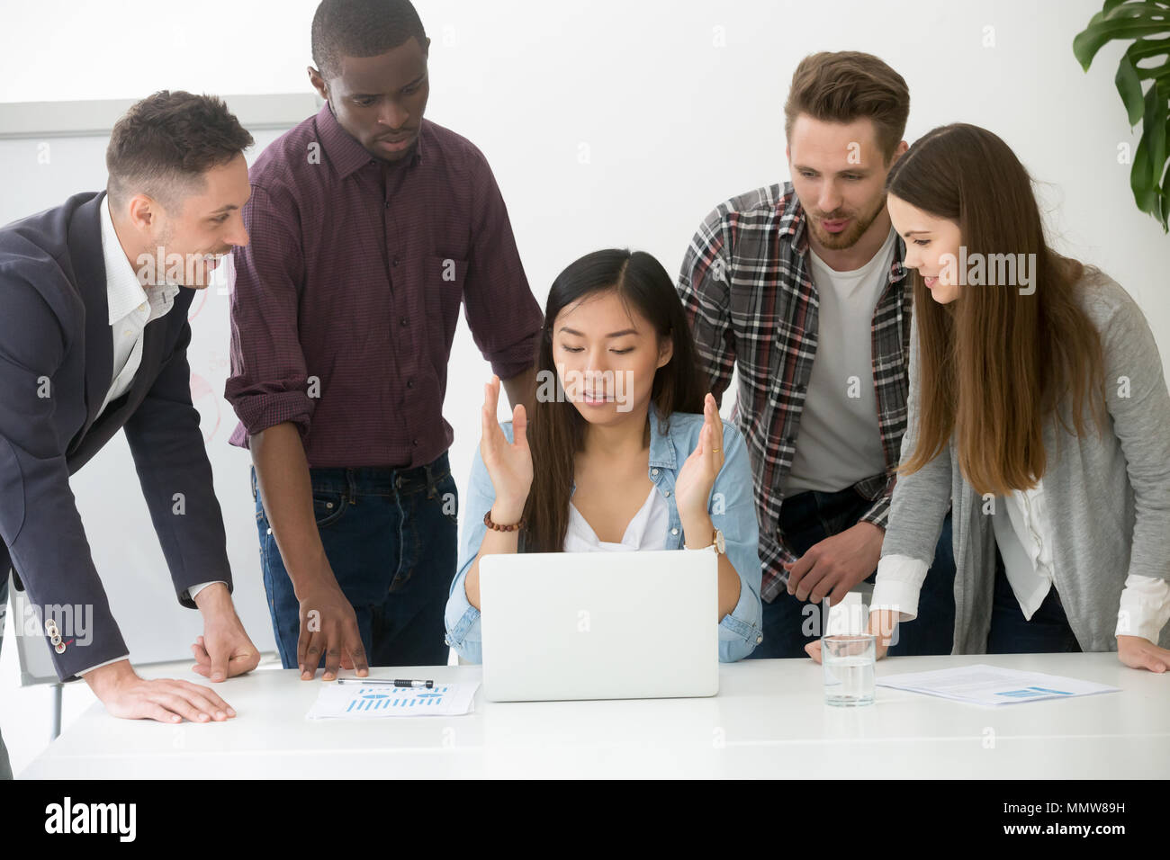 Serious multiracial team discussing solving business problem tog Stock Photo