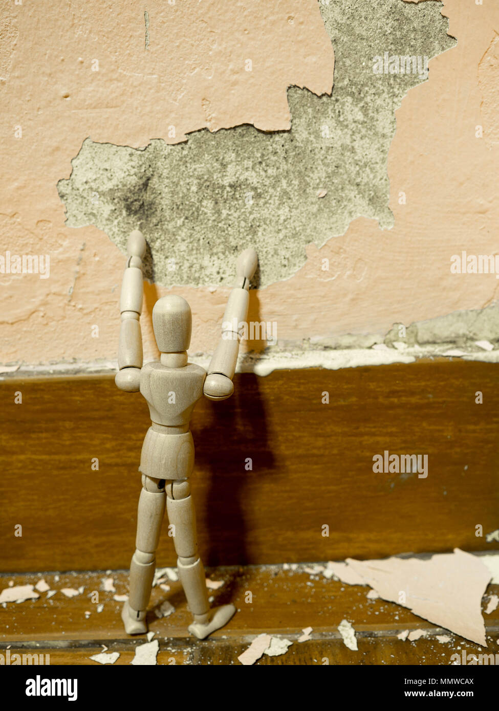 Wooden puppet tried to fix old Paint peeling plaster walls damage
