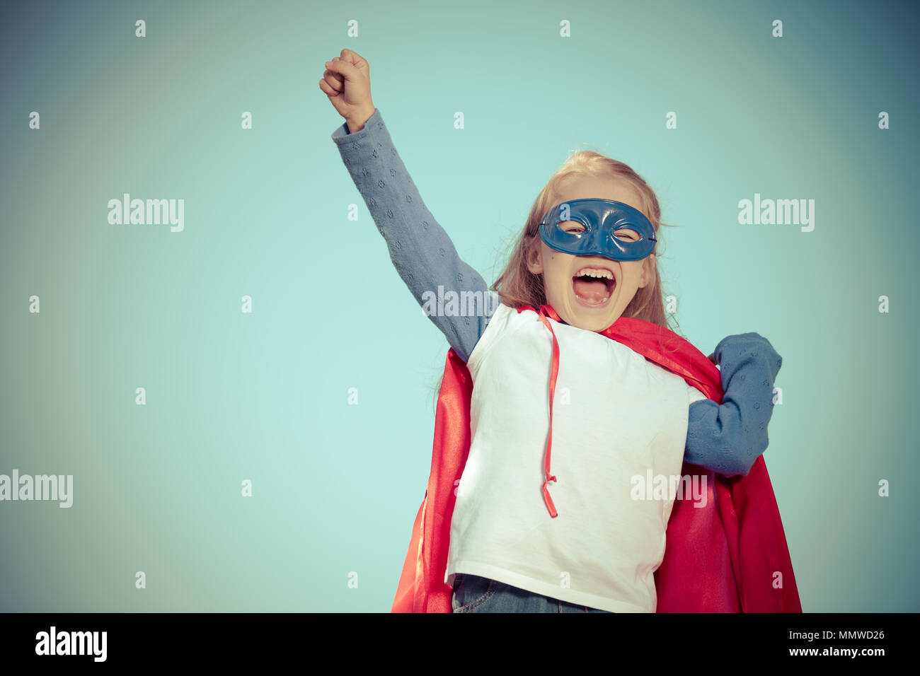 Funny little girl playing power super hero. Stock Photo