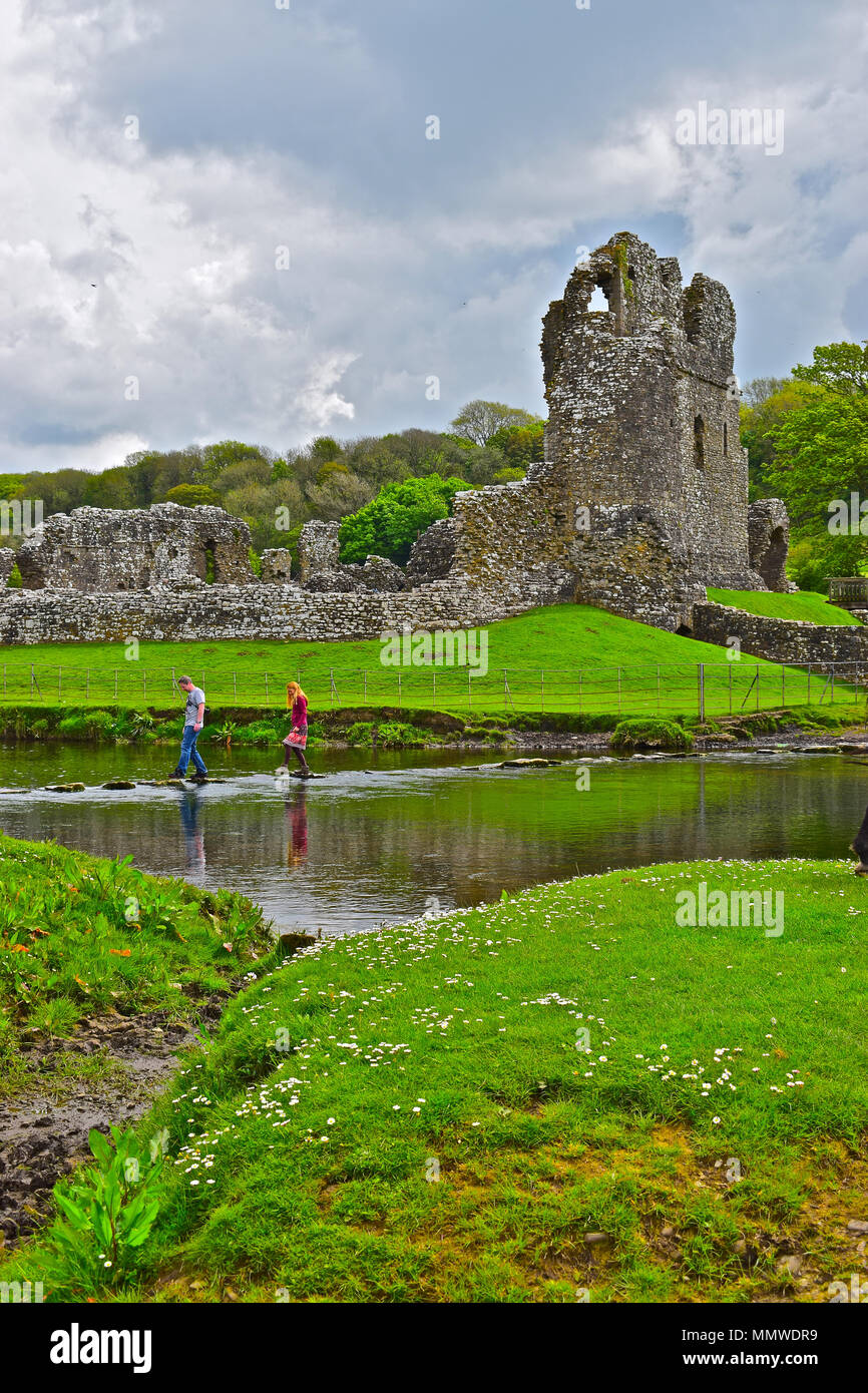 A young couple carefully cross the famous stepping stones over the