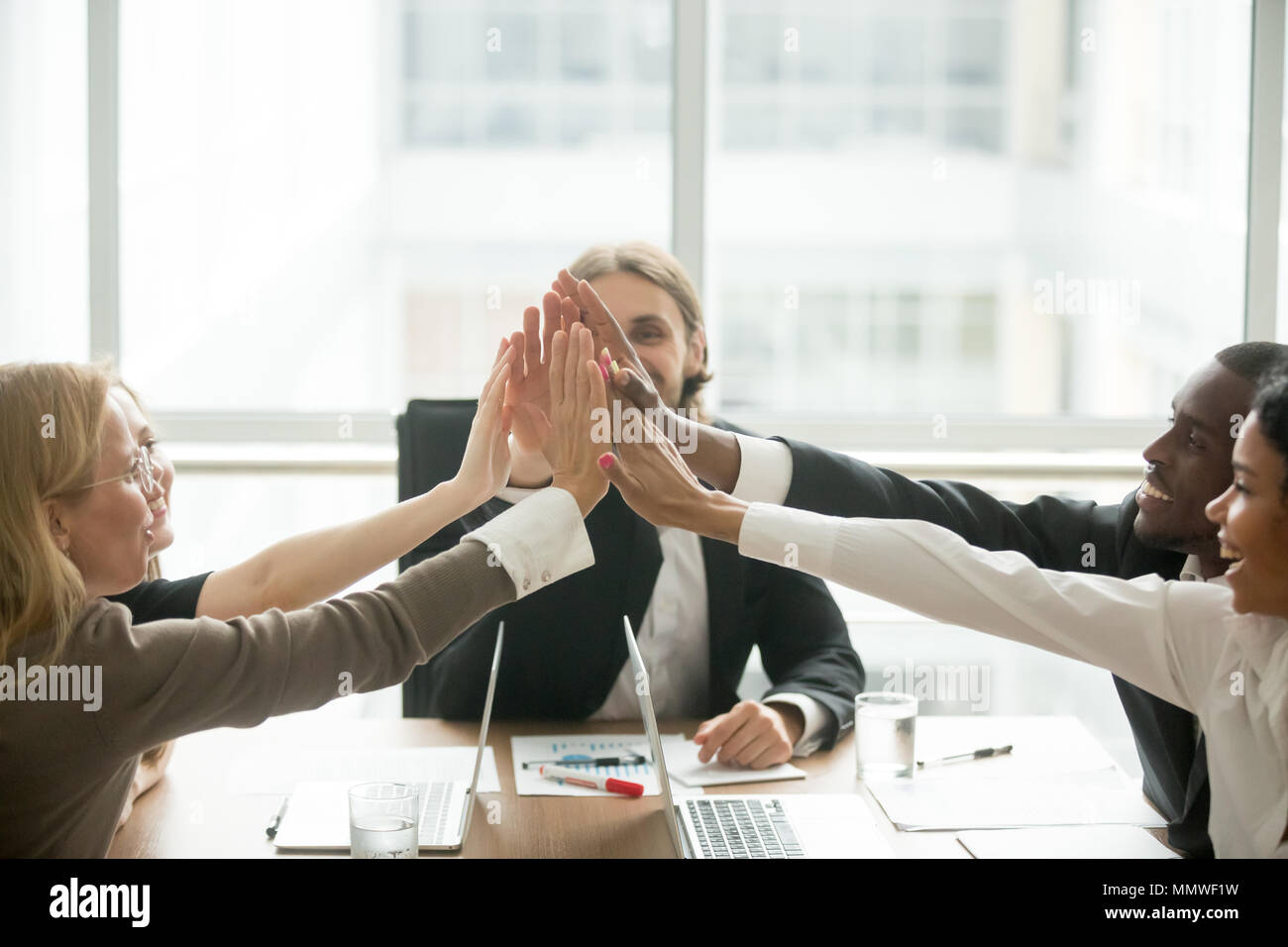 Excited happy multiracial business team giving high-five at offi Stock ...