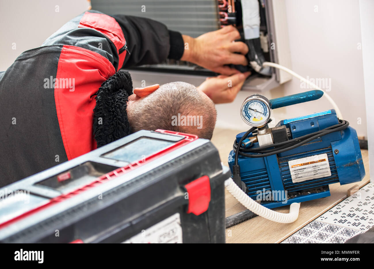 Technician vacuum pump evacuates and checking new air conditioner. Stock Photo
