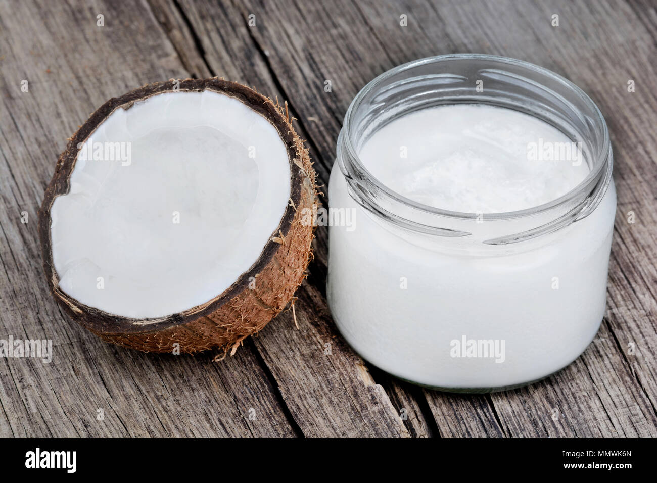 Coconut oil in glassware on wooden table Stock Photo