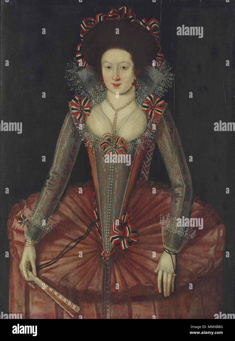 .  English: Portrait of a lady traditionally identified as (but not likely to be) Viscountess Cranborne (c.1623–1675), three-quarter-length, in a red and silver wheel farthingale and embroidered bodice, a fan-shaped lace ruff and cuffs and ribbons, holding a fan in her right hand.  . between circa 1610 and circa 1615. English School c. 1610-1615 Portrait of a Lady Stock Photo