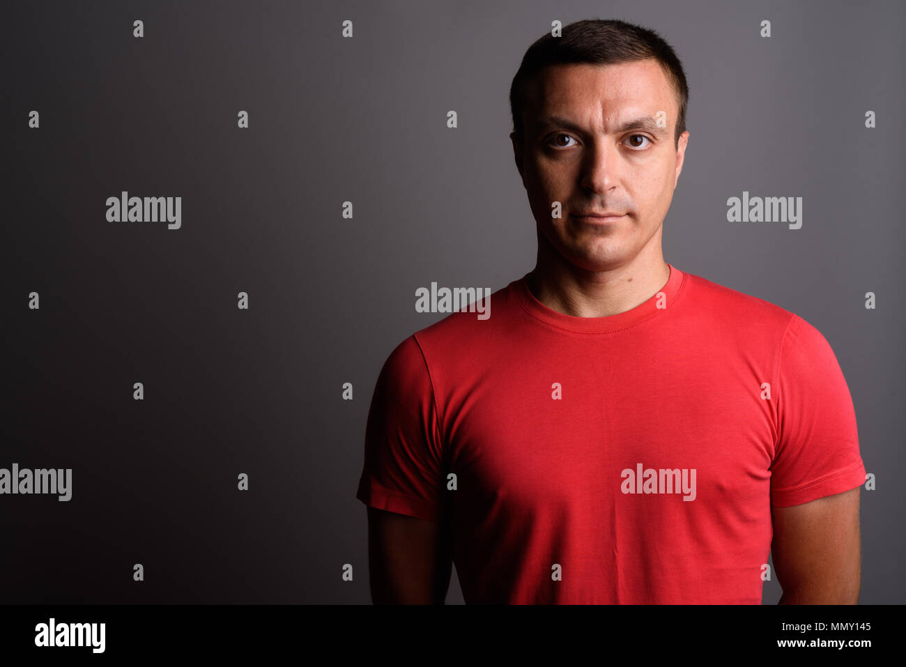 Man wearing red shirt against gray background Stock Photo - Alamy