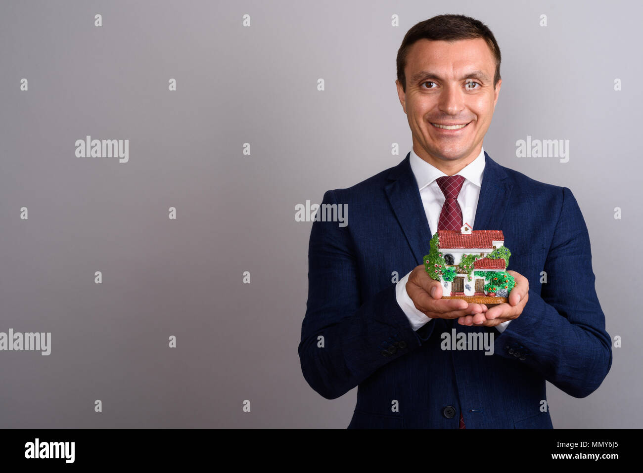 Businessman wearing suit against gray background Stock Photo - Alamy