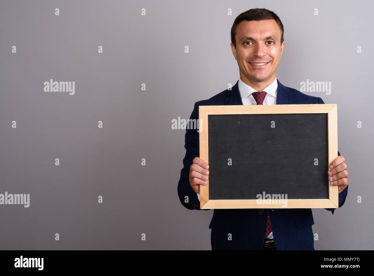 Businessman wearing suit against gray background Stock Photo - Alamy