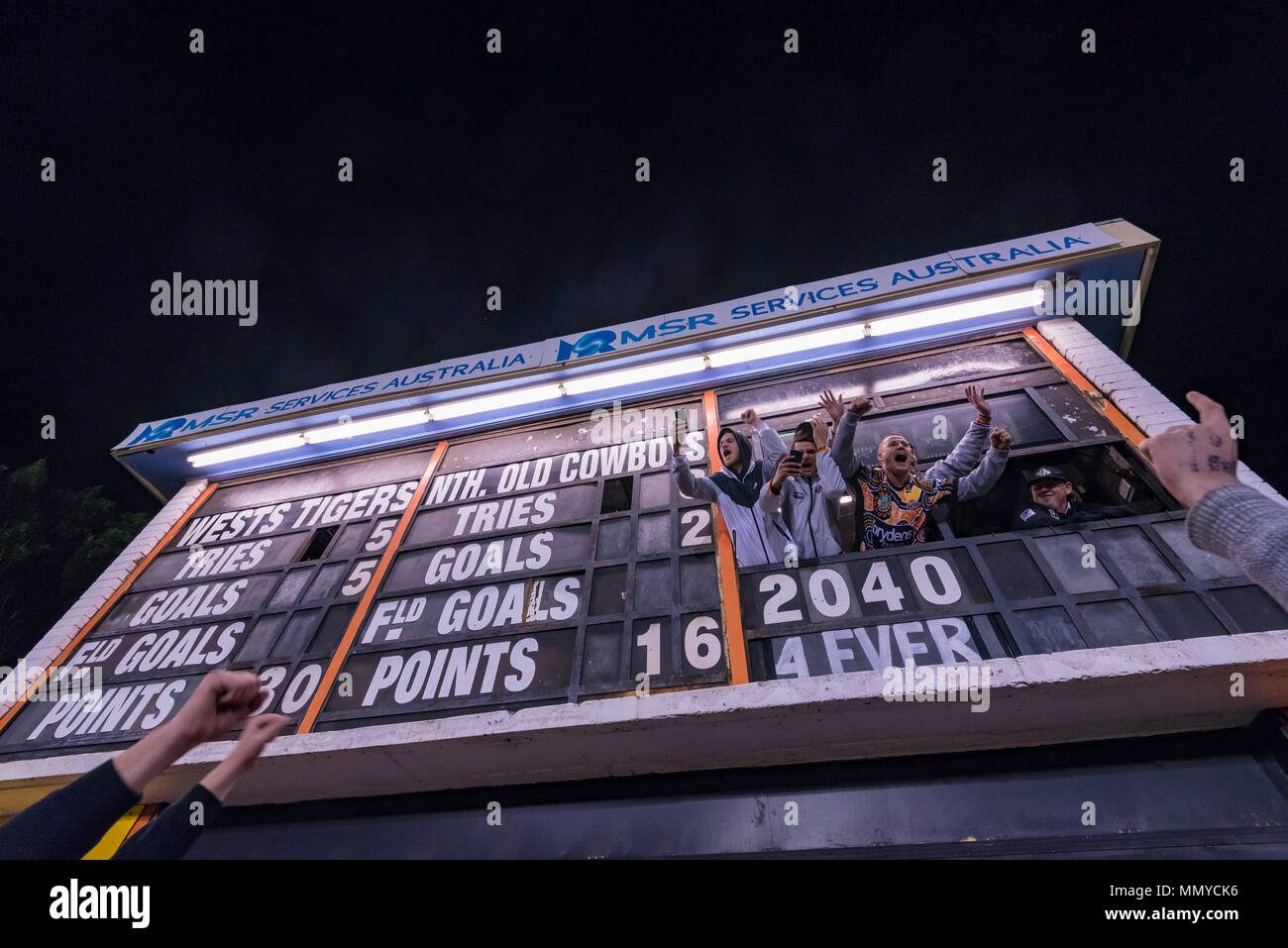 Scoreboard workers celebrate a Wests Tigers win over North Queensland Cowboys game at Sydney's Leichhardt Oval on May 10th, 2018 in Australia Stock Photo