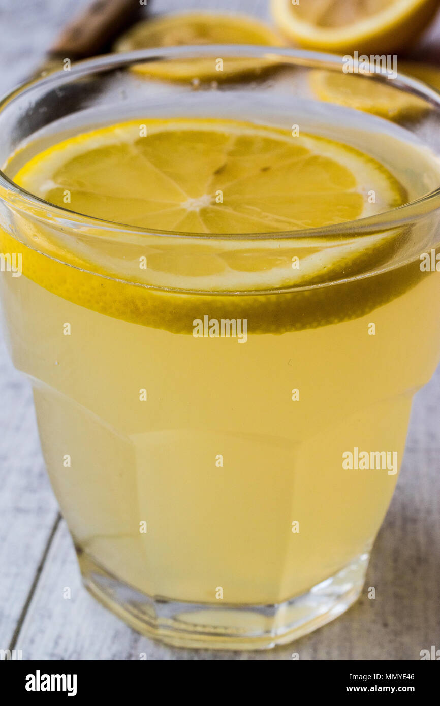 Lemon Liqueur Limoncello with lemon on white wooden surface. Beverage