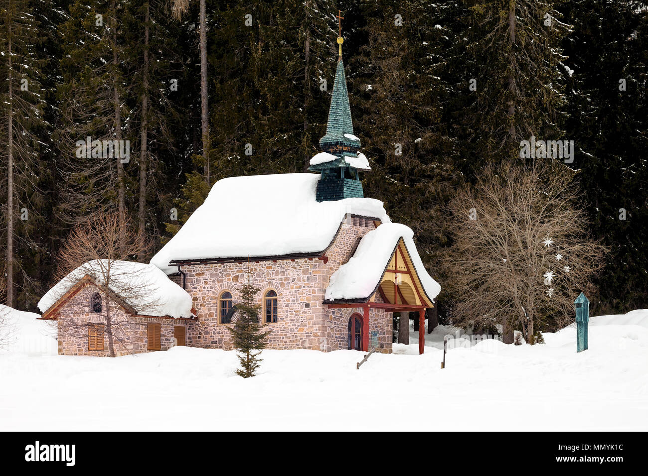 Church and snow covered trees behind, Lake of Braies, Dolomites, South Tyrol, Italy Stock Photo