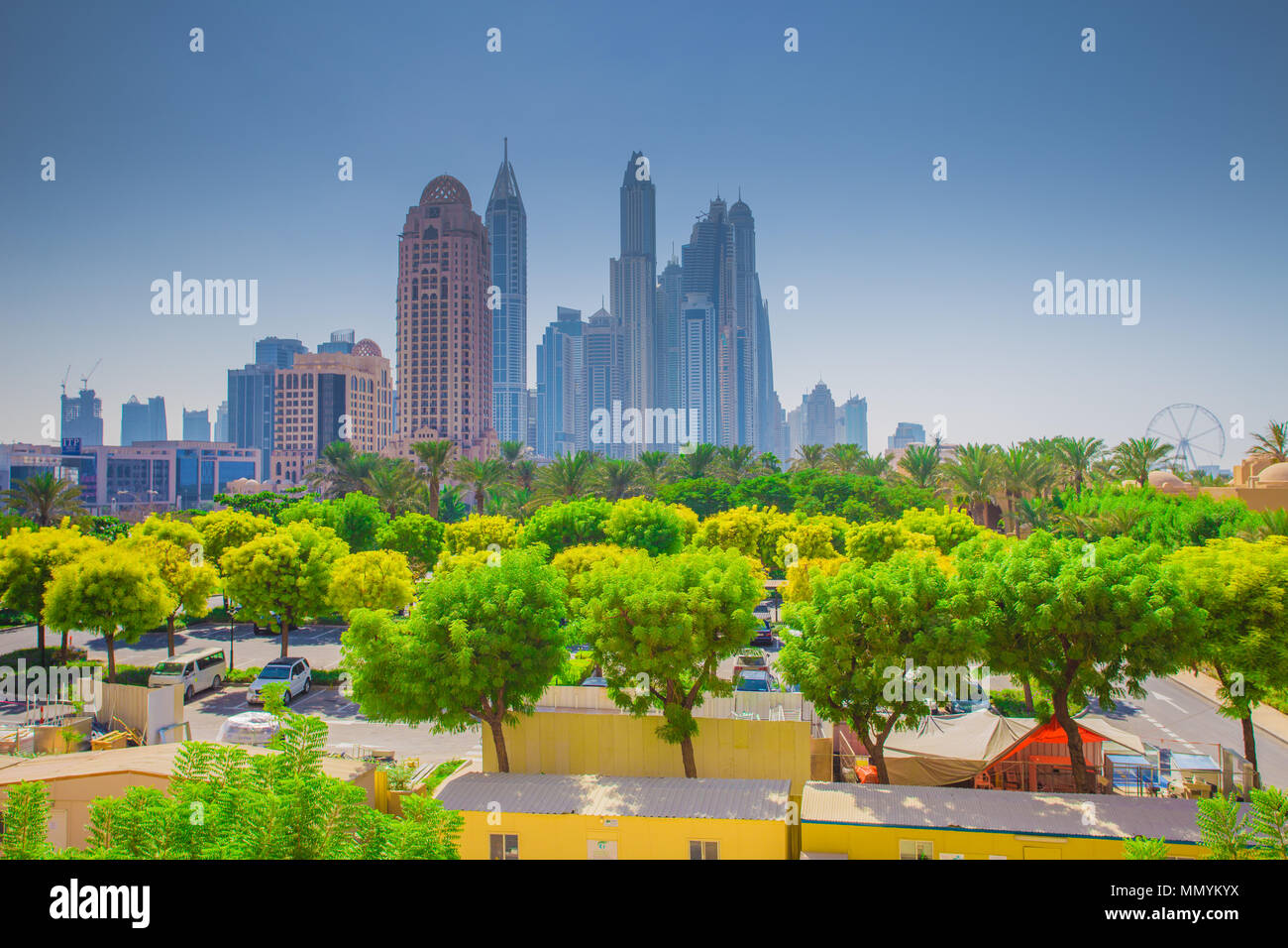 Dubai cityscape. Green trees on Dubai downtown background. Amazing colorful skyline. Stock Photo