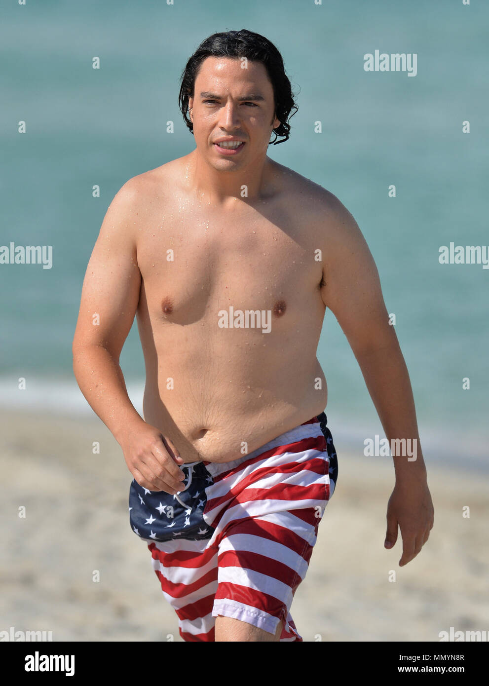 MIAMI BEACH, FL - MAY 14: Actor Jon Bass goes for a swim wearing American  Flag bathing suit at his South Beach Hotel on Mother's Day on May 14, 2017  in Miami