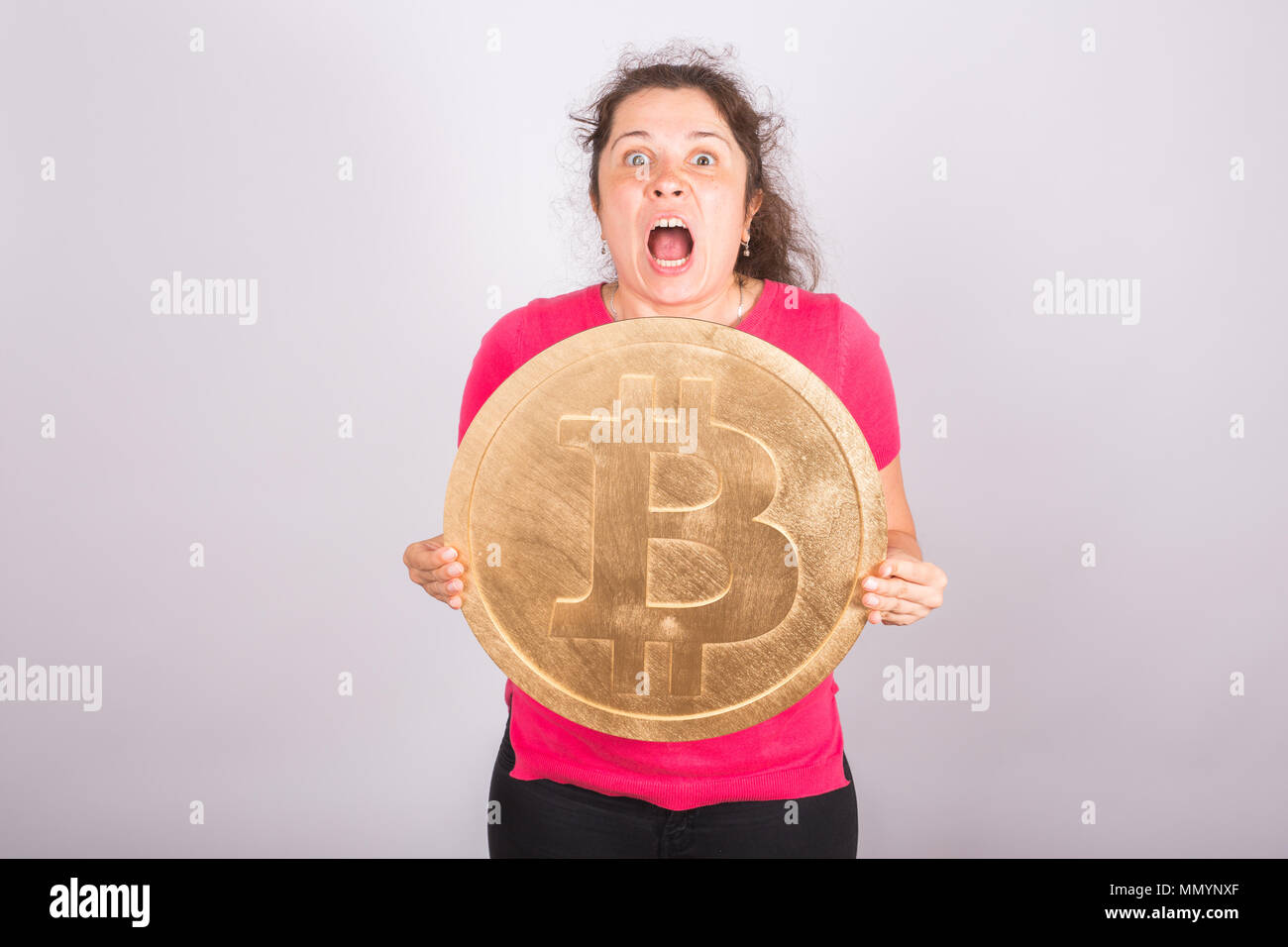 Portrait of a screaming woman holds big golden bitcoin in his arms. Girl in  panic of cryptocurrency crash Stock Photo - Alamy