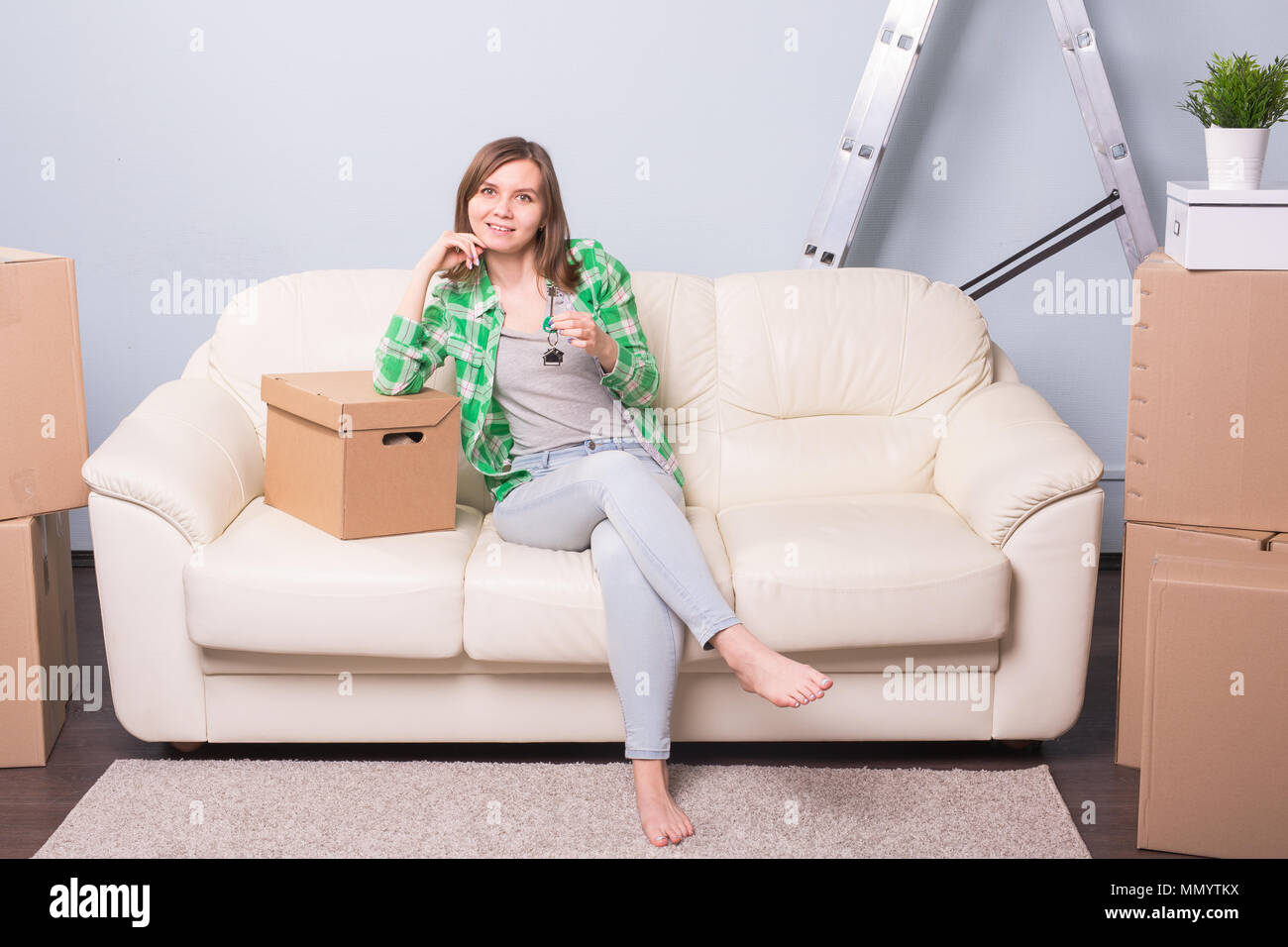 Happy young woman in her new home holding key Stock Photo - Alamy
