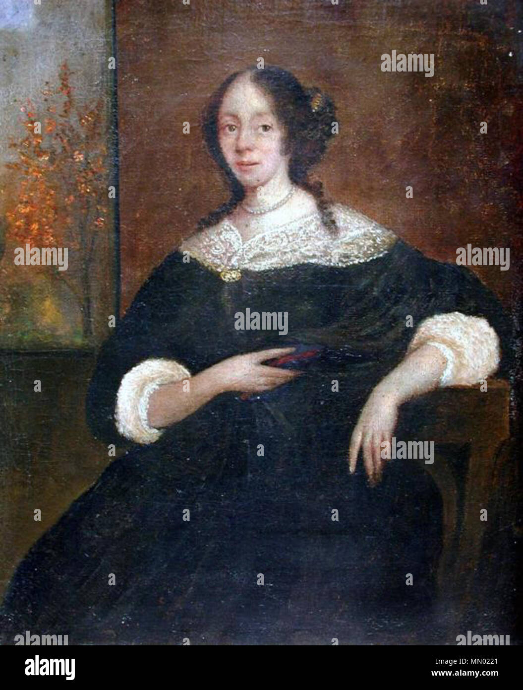 .  The image is of a young woman seated in a chair. Her chestnut hair is curled, gathered in a cluster at the back of her neck; tendrils fall on both shoulders. At her neck is a pearl necklace. She wears a dress that appears to be black, with a broad lace collar gathered at the front of the bodice by an ornament. The white lace sleeves of her undergarment show beneath the dress, and are gathered below the elbow. A dark scarf hangs over her left arm and is gathered behind her right hand, which also holds a small book. The upper part of her full skirt is visible, as is the wooden open back of th Stock Photo