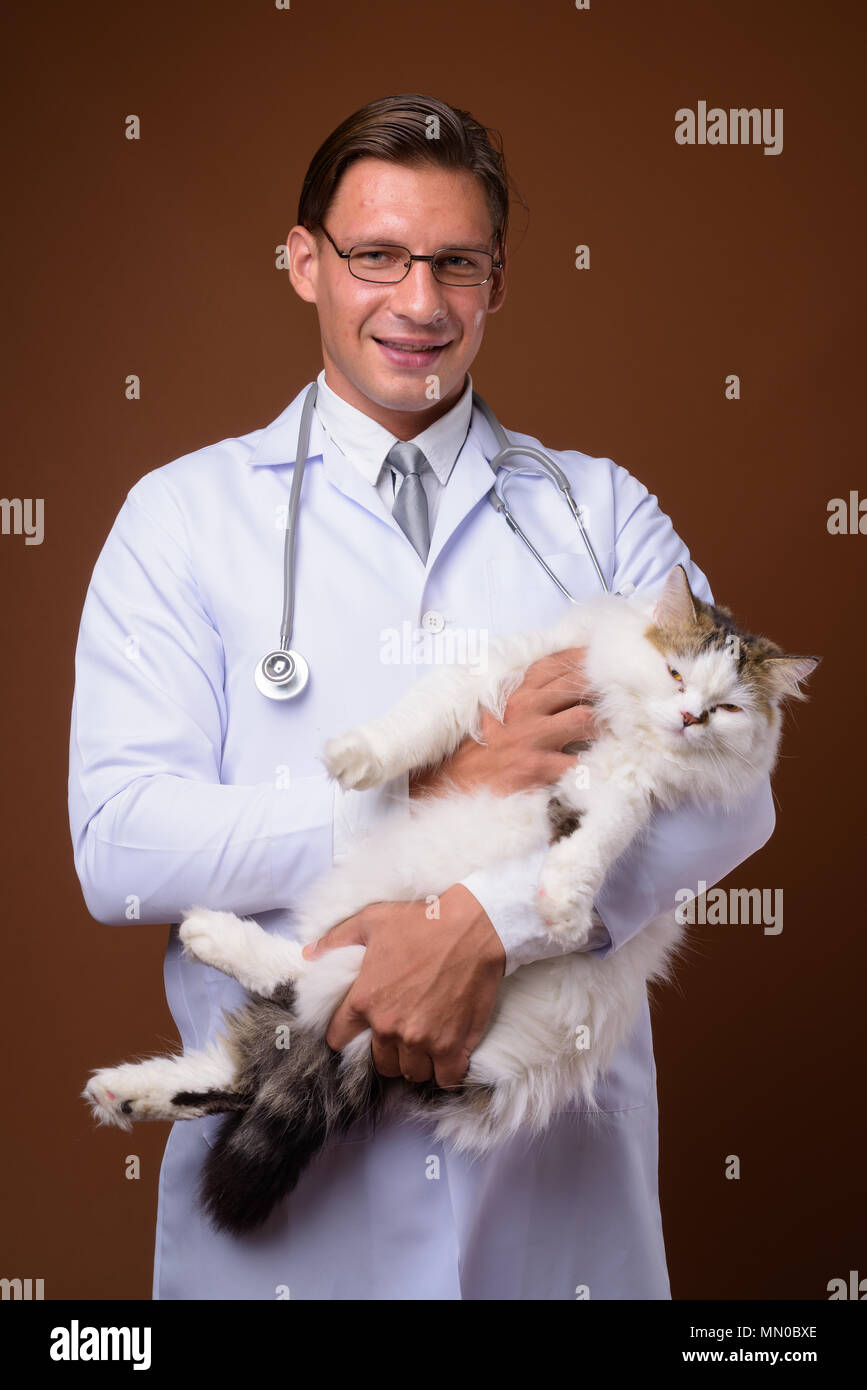 Studio shot of man doctor against brown background Stock Photo