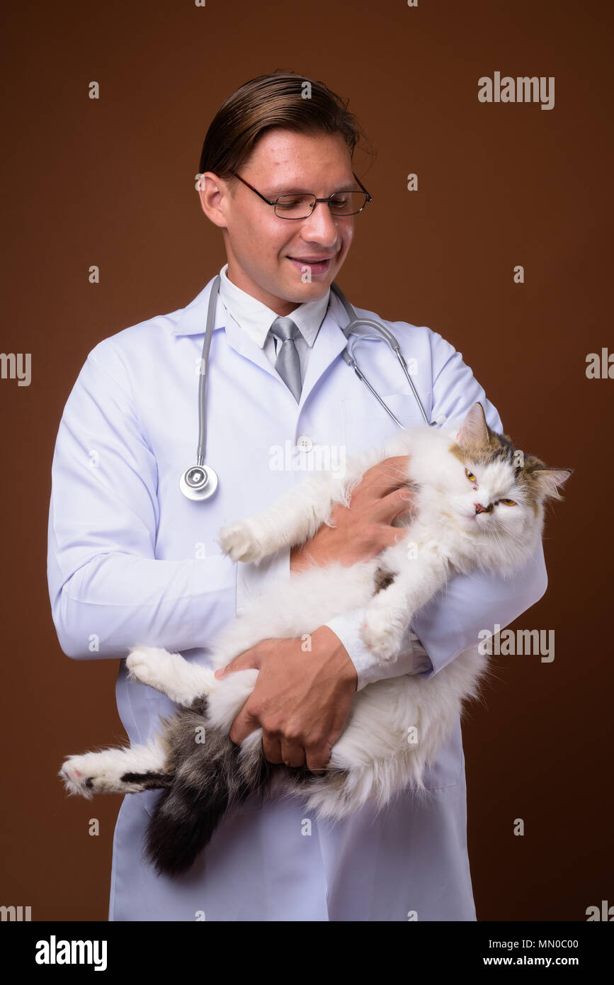 Studio shot of man doctor against brown background Stock Photo