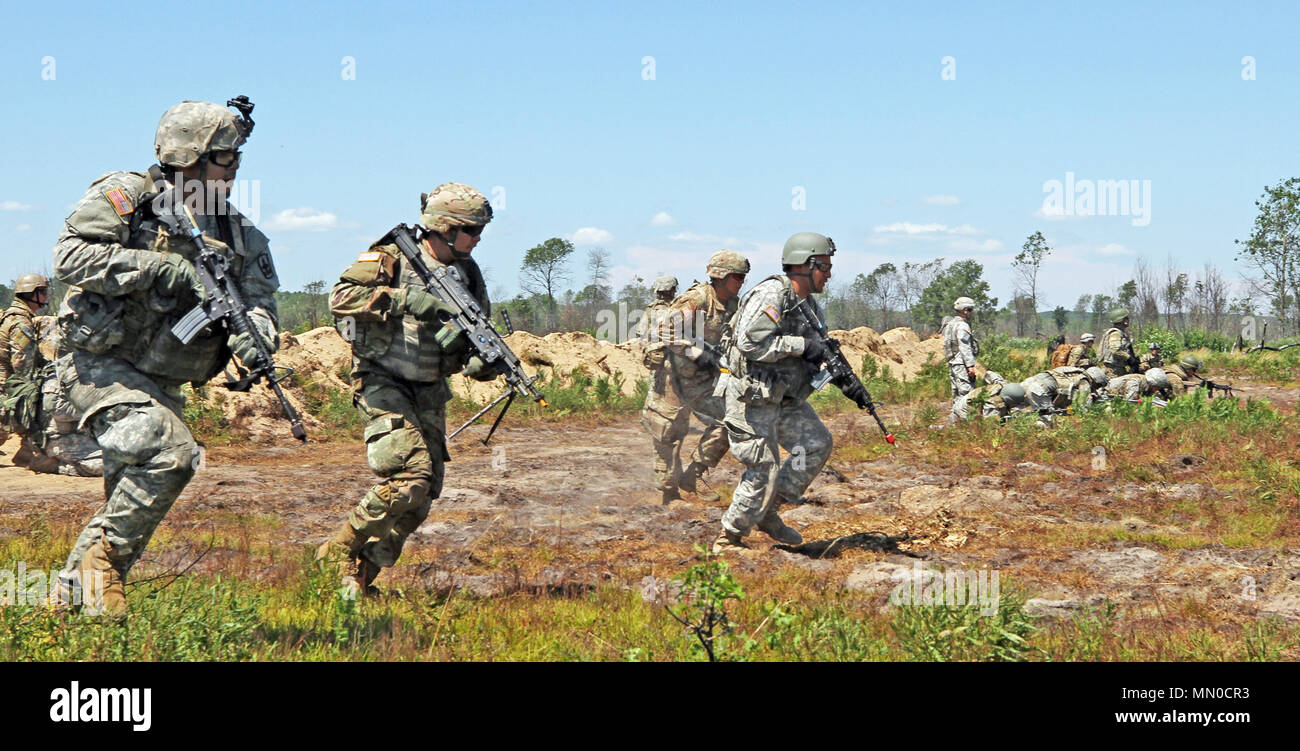 Infantrymen from Bravo Company, 1st Battalion, 158th Infantry Regiment, Arizona National Guard assault across a range at the 40 Complex of Camp Grayling Joint Maneuver Training Center during a Northern Strike 17 field training exercise, Aug. 1, 2017. The newly accredited NS 17 demonstrates the Michigan National Guard’s ability to provide accessible, readiness-building opportunities for military units from all service branches to achieve and sustain proficiency in conducting mission command, air, sea, and ground maneuver integration, together with the synchronization of fires in a joint, multin Stock Photo