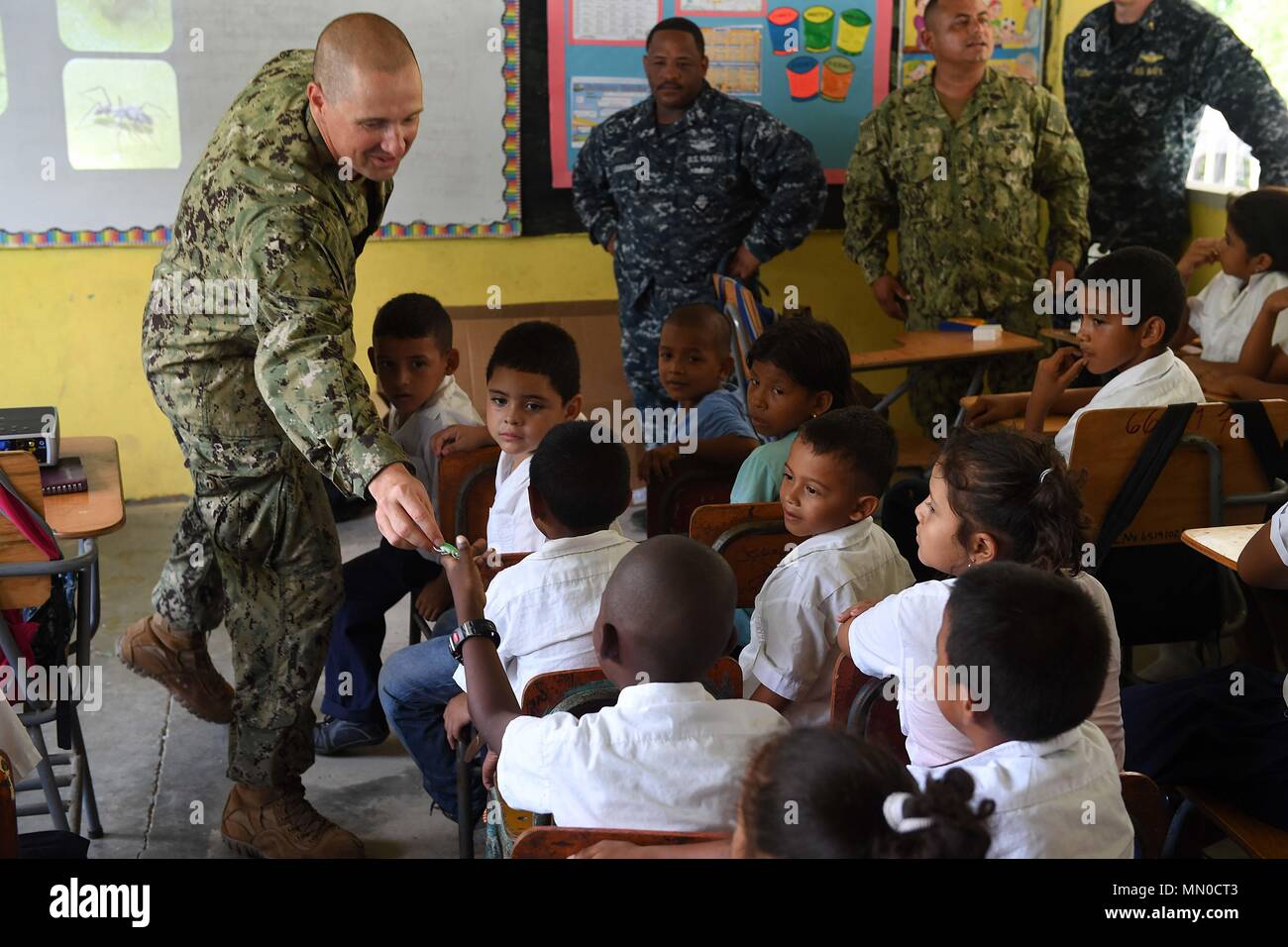 170801-N-BK435-0159 SILIN, Honduras (Aug. 1, 2017) Lt. Cmdr. Ian Sutherland, technical director for the Navy Entomology Center of Excellence, hands a student a toy bug during an entomology class at República de Colombia Elementary School during a Southern Partnership Station 17 community relations project (COMREL). SPS-EPF 17 is a U.S. Navy deployment, executed by U.S. Naval Forces Southern Command/U.S. 4th Fleet, focused on subject matter expert exchanges with partner nation militaries and security forces in Central and South America. (U.S. Navy photo by Mass Communication Specialist 1st Clas Stock Photo