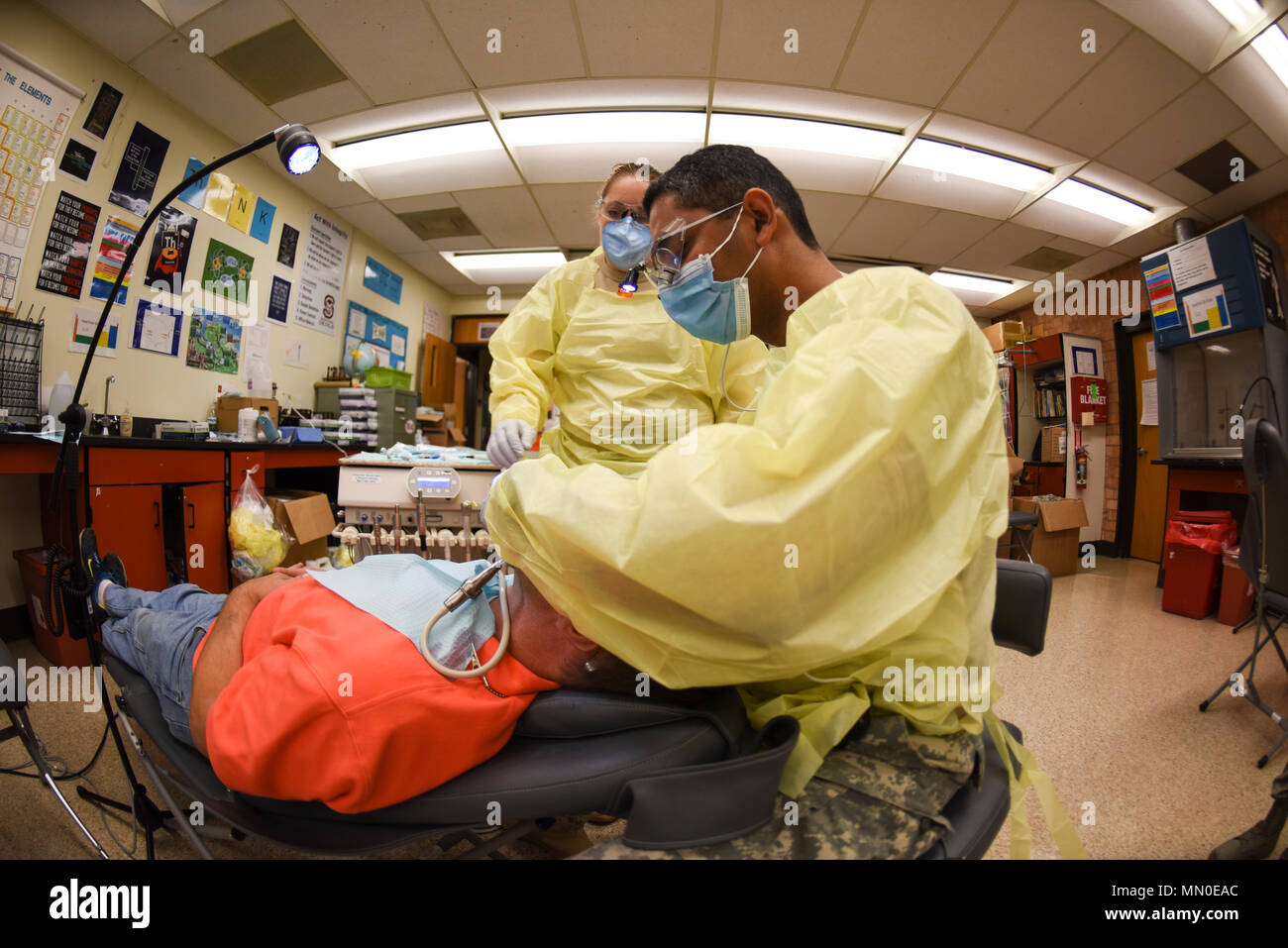 Army Capt. Shyam Shivareddy, a dentist assigned to 455th Dental Company, Fort Devens Reserve Forces Training Area, Mass., fills a tooth at Swain County High School during Smoky Mountain Medical Innovative Readiness Training in Bryson City, N.C., on Aug. 3, 2017. Smoky Mountain Medical IRT provides no-cost medical, dental, vision and veterinary services to the residents of Swain County, Clay County and the surrounding areas while satisfying training requirements for active, reserve and National Guard service members and units. Stock Photo