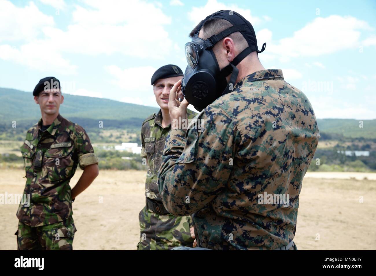 A U.S. Marine with Black Sea Rotational Force 17.1 teach the Romanian military how to properly don the M50 gas mask aboard Novo Selo Training Area, Bulgaria, Aug. 2, 2017. This range was a part of Exercise Platinum Lion 17.2, a multinational exercise to build relationships with NATO Allies and partner nations through combined arms training. (U.S. Marine Corps photo by Sgt. Patricia A. Morris) Stock Photo