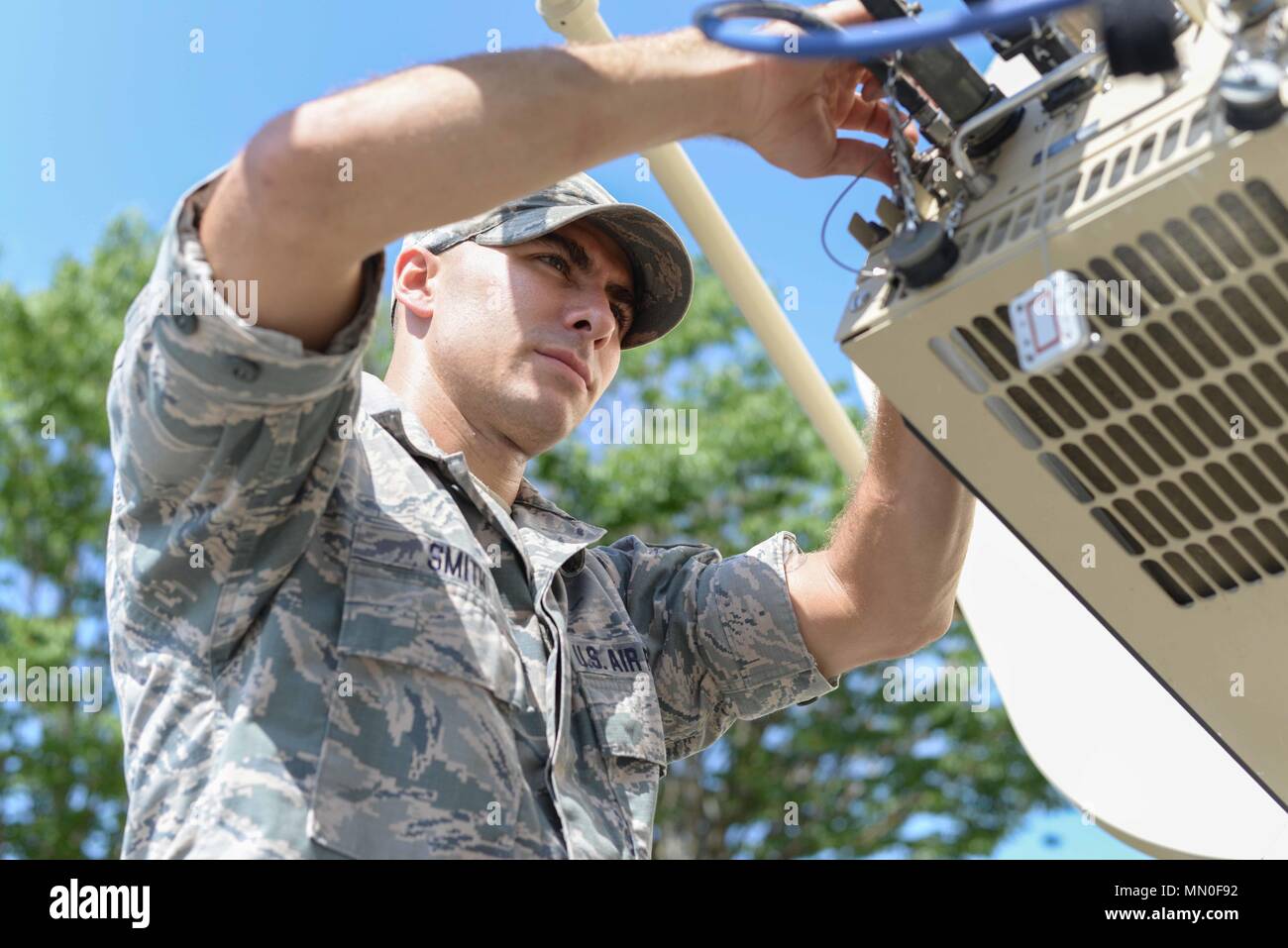 U.S. Air Force Staff Sgt. Travis Smith, an Airman with the 265th Combat  Communications Squadron (CBCS), Maine Air National Guard, inspects a Large  Aperture Antennae (LAA) located at the South Portland Air