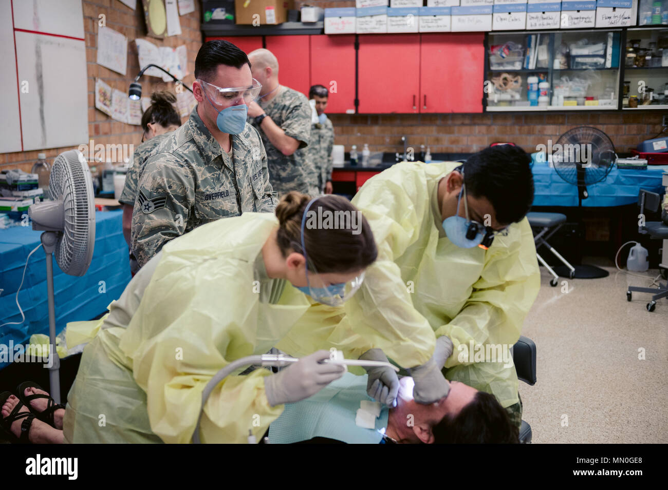 Air Force Senior Airman Anthony Overfield, a medical technician assigned to the 107th Medical Group, Niagara Falls Air Reserve Station, New York Air National Guard, assists Staff Sgt. Ashley Hyatt, a dental technician assigned to the 452nd Aerospace Medical Squadron, Air Force Reserve Command, March Air Reserve Base, Calif., and Army Maj. Dheera Pamidimukkala, a dentist assigned to the 455th Dental Company, Devens Reserve Forces Training Area, Army Reserve Command, Mass., with a dental procedure as part of the Smoky Mountain Innovative Readiness Training mission, Bryson City, N.C., Aug. 4, 201 Stock Photo