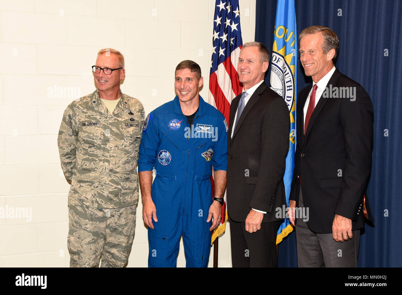 Colonel Michael Hopkins, NASA Astronaut, posed for a photo with Brig. Gen. Joel De Groot, SDNG assistant adjutant general for air, Gov. Dennis Daugaard, and U.S. Sen. John Thune here, Aug. 4.  Hopkins shared his experiences as an astronaut with members of the 114th Fighter Wing.  (U.S. Air National Guard photo by Master Sgt. Christopher Stewart/Released) Stock Photo