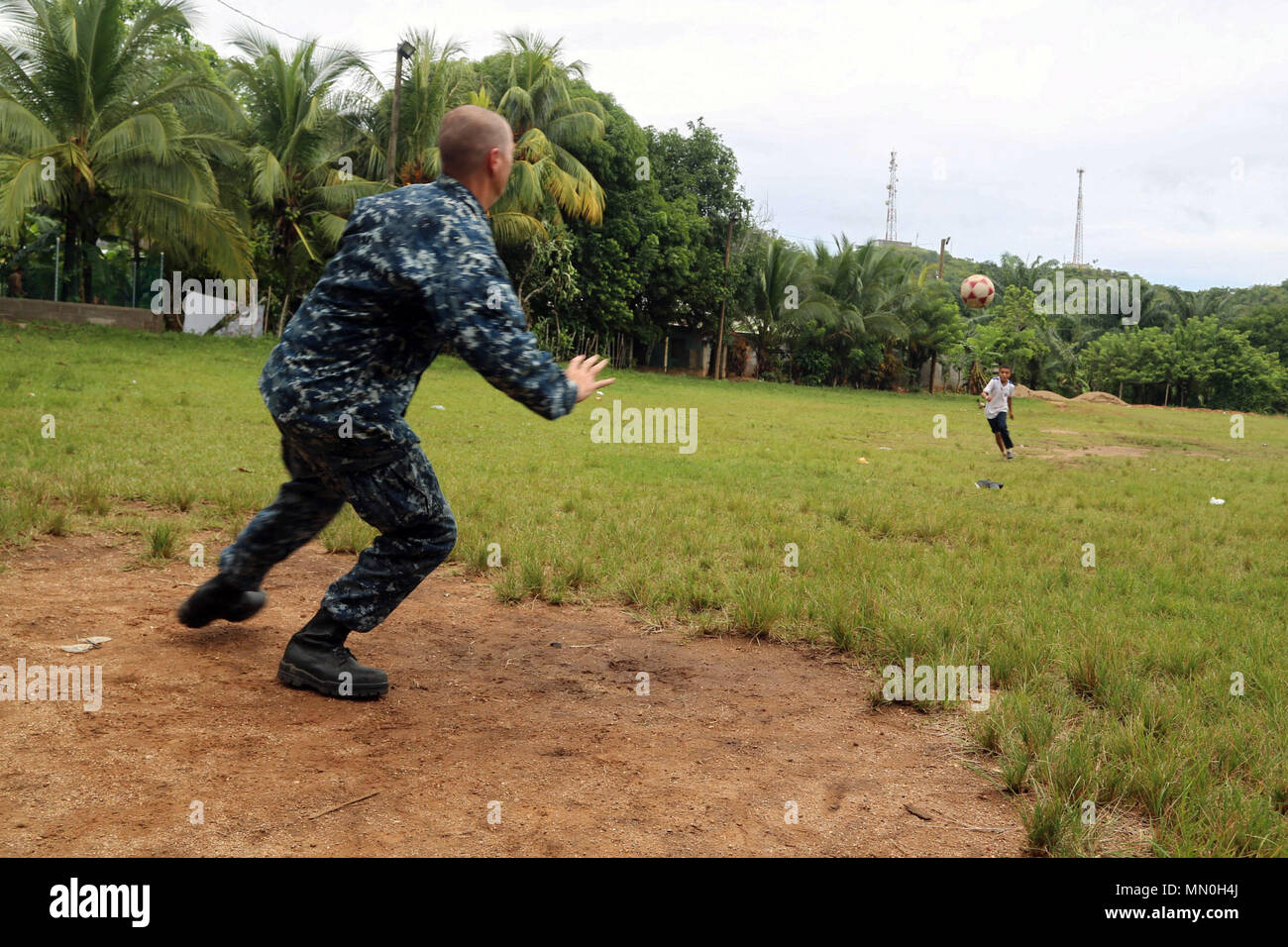 170804-A-QE286-405 TARROS, Honduras (Aug. 4, 2017) U.S. Navy Lt. Cmdr. Ian Sutherland, technical director for the Navy Entomology Center of Excellence, plays soccer with Honduran elementary school students at Escuela Rural Mixta Luz Infantil, during a Southern Partnership Station 17 community relations (COMREL) project. SPS-EPF 17 is a U.S. Navy deployment, executed by U.S. Naval Forces Southern Command/U.S. 4th Fleet, focused on subject matter expert exchanges with partner nation militaries and security forces in Central and South America. (U.S. Army photo by SPC Judge Jones/Released) Stock Photo