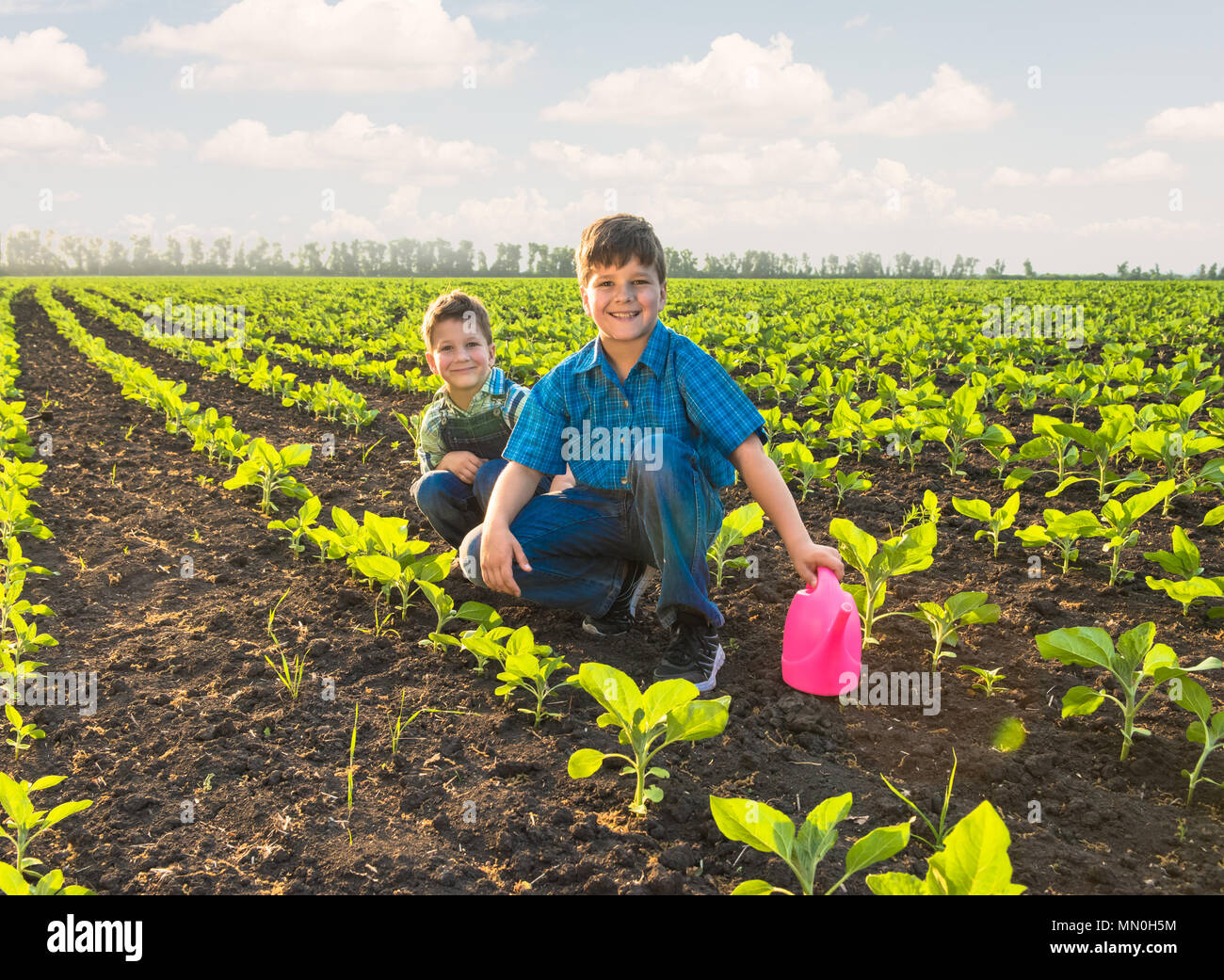 Happy small farmers in spring field gardening Stock Photo