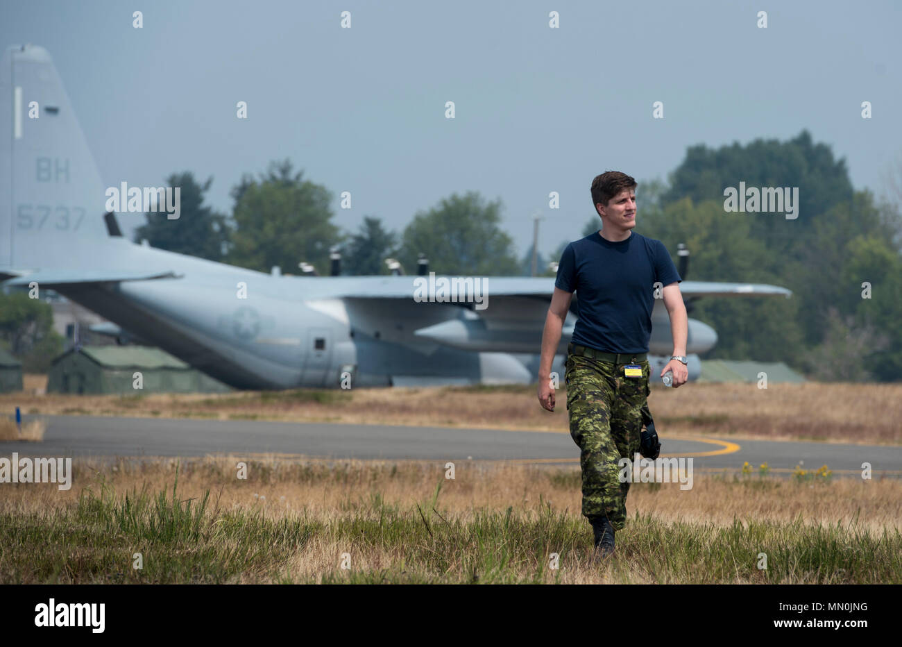 Royal Canadian Air Force Corporal Kyle Judd, avionics technician, 436  Transport Squadron, Canadian Air Forces Base Trenton, Ontario, Canada,  walks on the flightline during Exercise Mobility Guardian, Joint Base  Lewis-McChord, Wash., Aug.