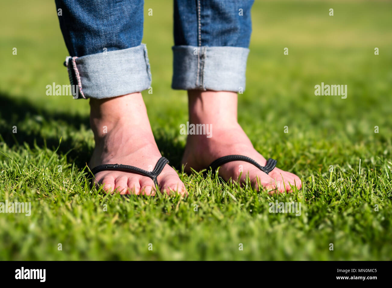 Woman wearing flip flops on a meadow Stock Photo