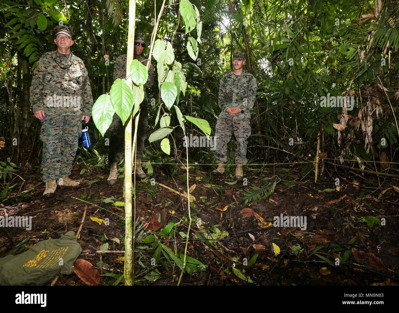 U.S. Marine Corps Lt. Gen. David H. Berger left, commander of U.S. Marine Corps Forces, Pacific, listens to the story of Gunnery Sgt. John Basilone during a visit of the fighting hole on Bloody Ridge in Guadalcanal, Solomon Islands, Aug. 8, 2017. The tour was used to teach Marines with 1st Marine Division and MARFORPAC about the small unit leadership used during the Battle of Guadalcanal that was held from Aug. 7, 1942 to Feb. 9, 1943. (U.S. Marine Corps photo by Sgt. Wesley Timm) Stock Photo