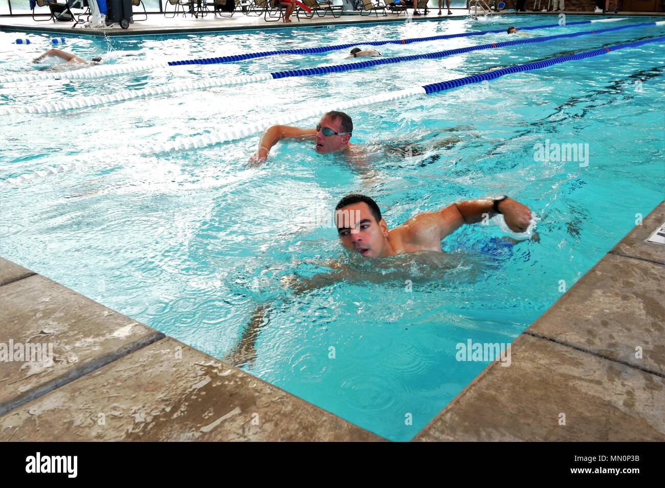 Roberto Molineros, 50th Space Communications Squadron satellite control operator (right), and Justin Halterman, 4th Space Operations Squadron first sergeant (left), compete side-by-side in the 400 meter swim portion of the triathlon at Schriever Air Force Base, Colorado, Aug. 4, 2017. The triathlon also consisted of a bike and run. (U.S. Air Force photo/Halle Thornton) Stock Photo